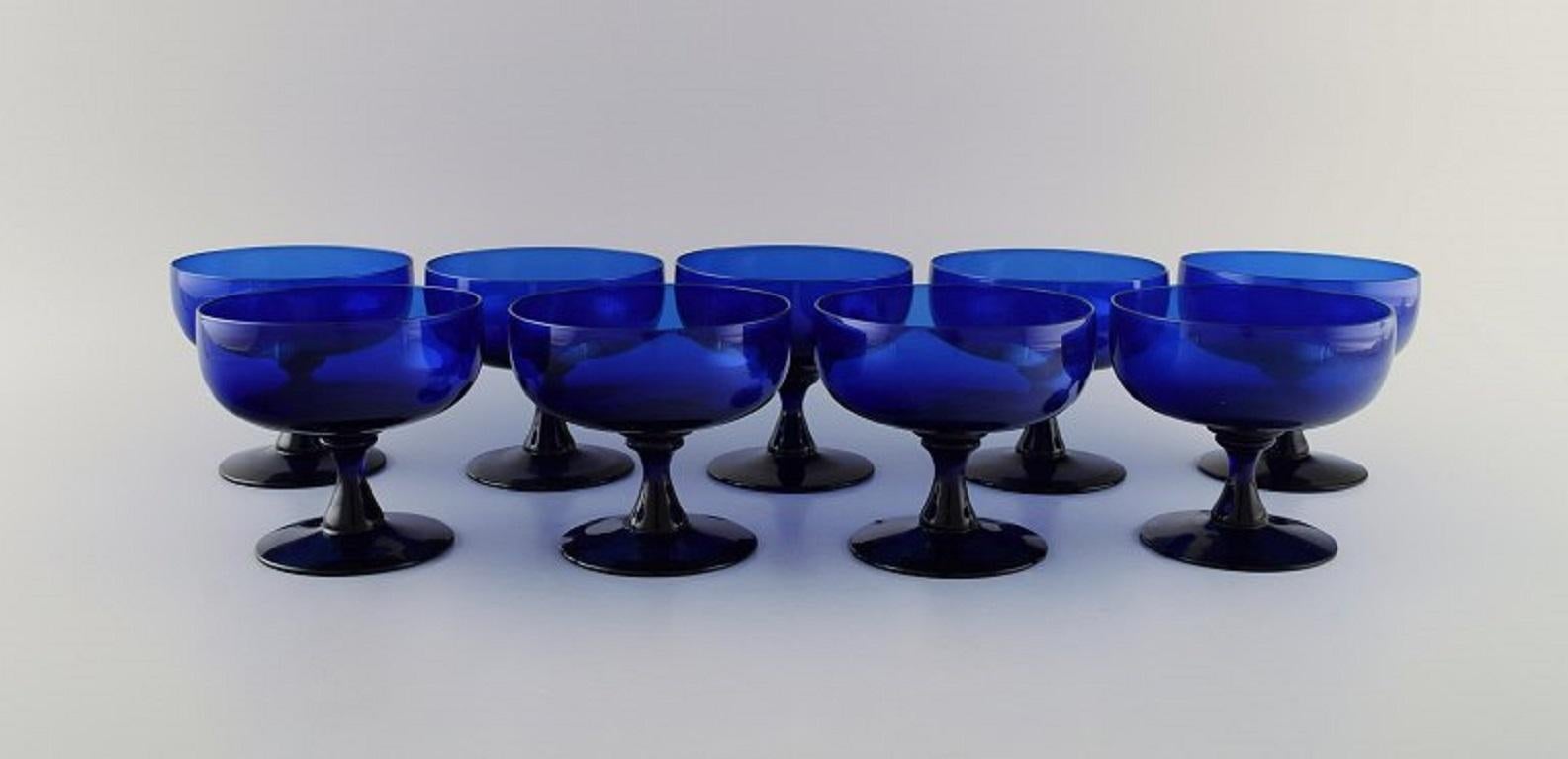 Monica Bratt pour Reijmyre. 9 Verres en verre d'art soufflé à la bouche de couleur bleue. 
Design suédois, milieu du 20e siècle.
Mesures : 10.3 x 9,5 cm.
En parfait état.