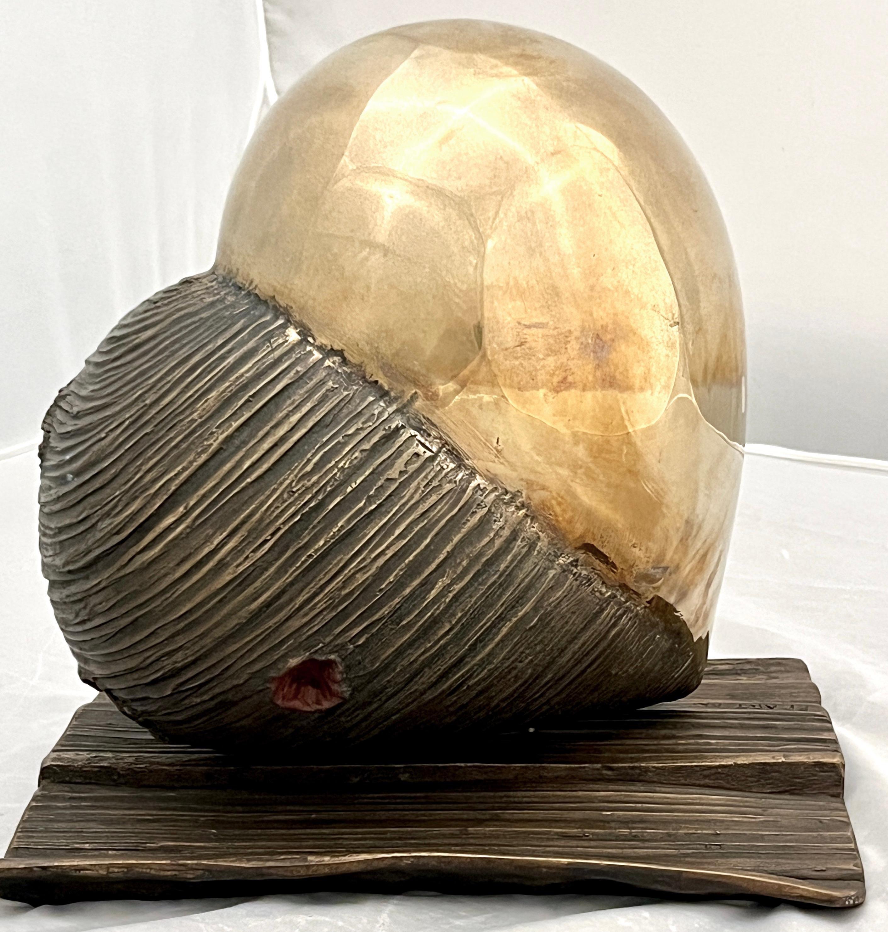 This contemporary Italian sculpture, a Work of Art by the woman artist Monica Foglia, represents a human heart sculpted in bronze. The 2 finishes, half in polished gold bronze and the other half in textured rough bronze tell our story of simple