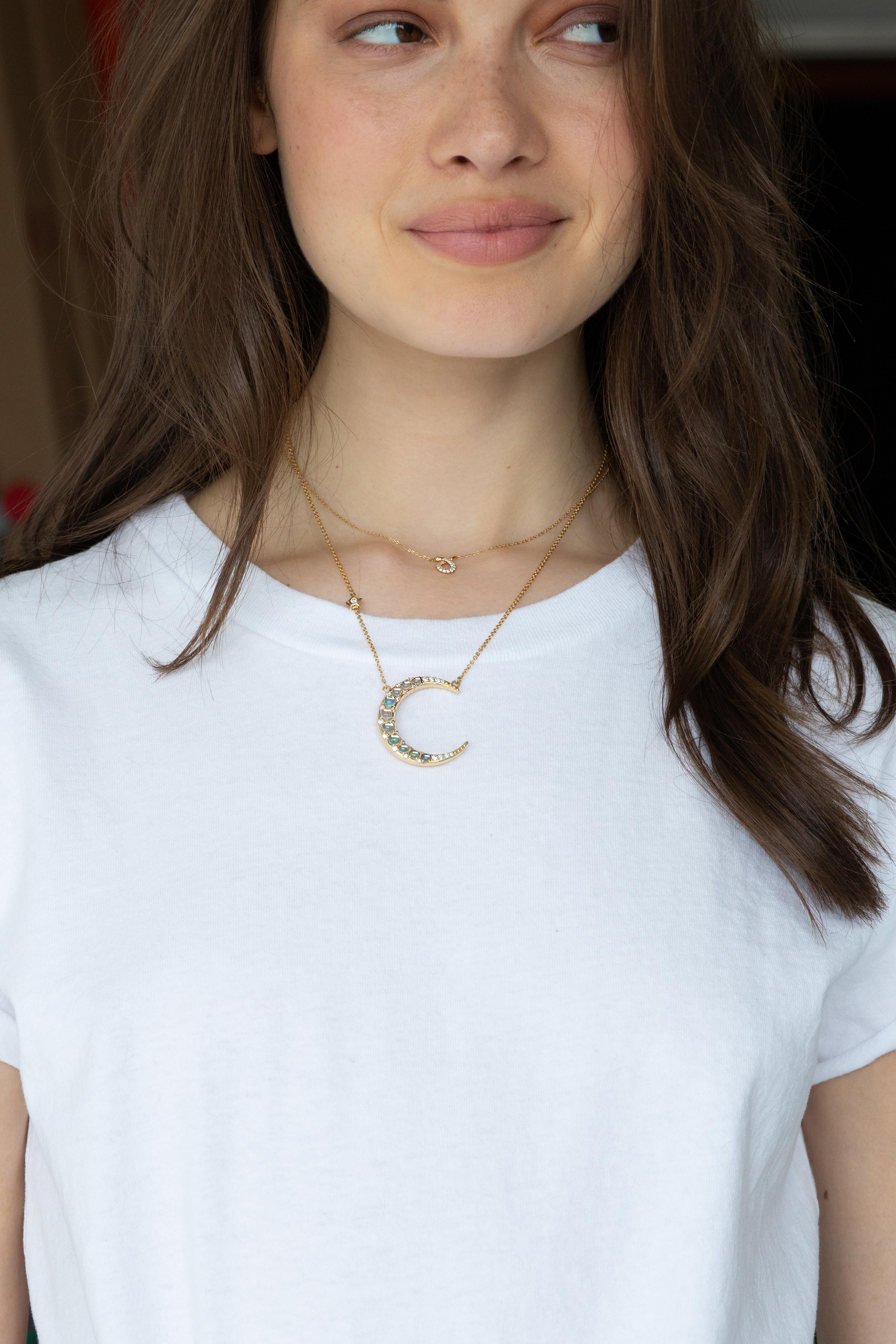 From the Sun, Moon and Stars collection, this Monica Rich Kosann 18K Yellow Gold charm necklace inspires the mystical quality of the crescent moon, featuring water opal cabochons and white diamond accents.
It is presented on an 18” cable chain with
