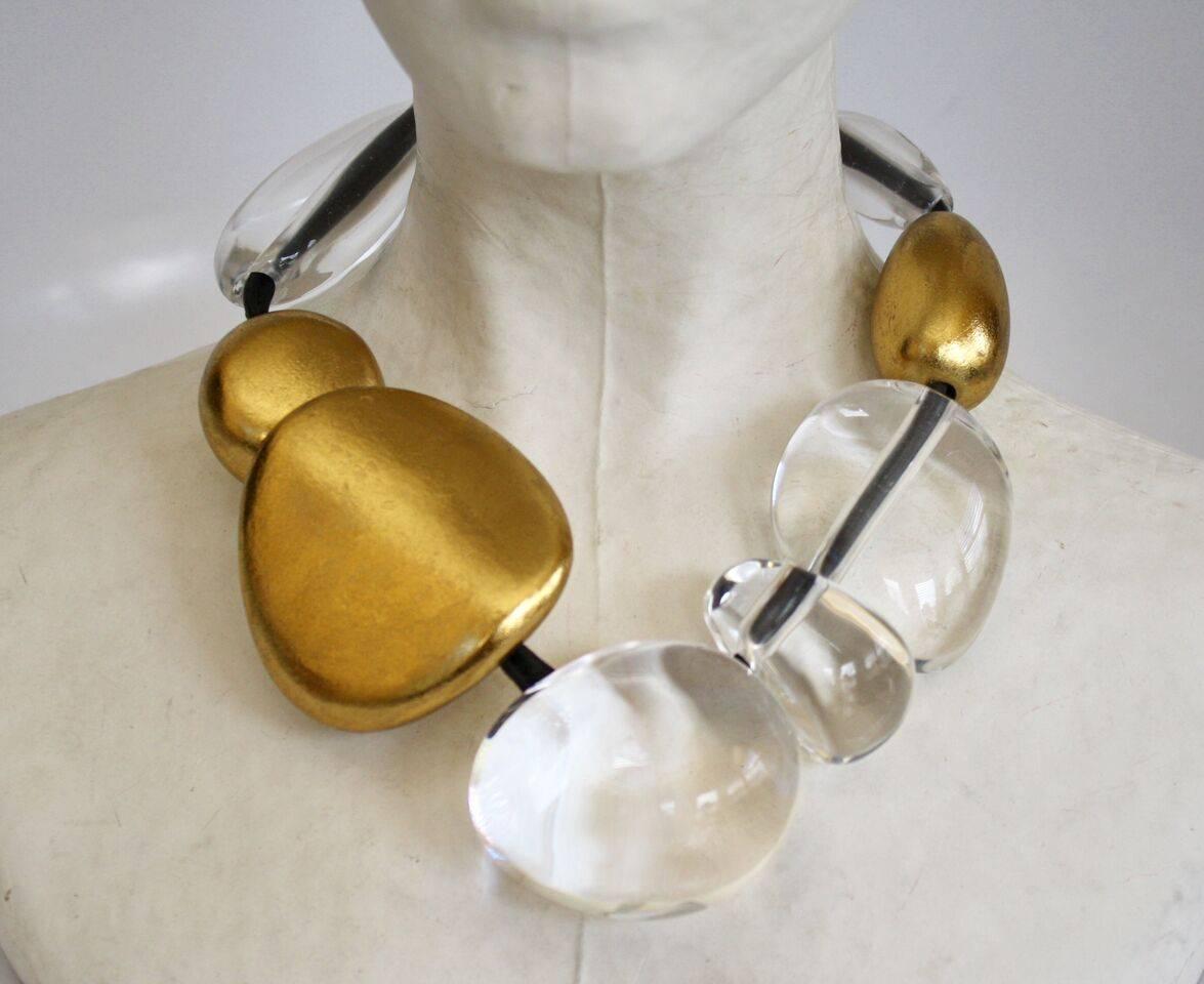 Clear acrylic and gold leaf bead necklace with leather cord from Monies. 