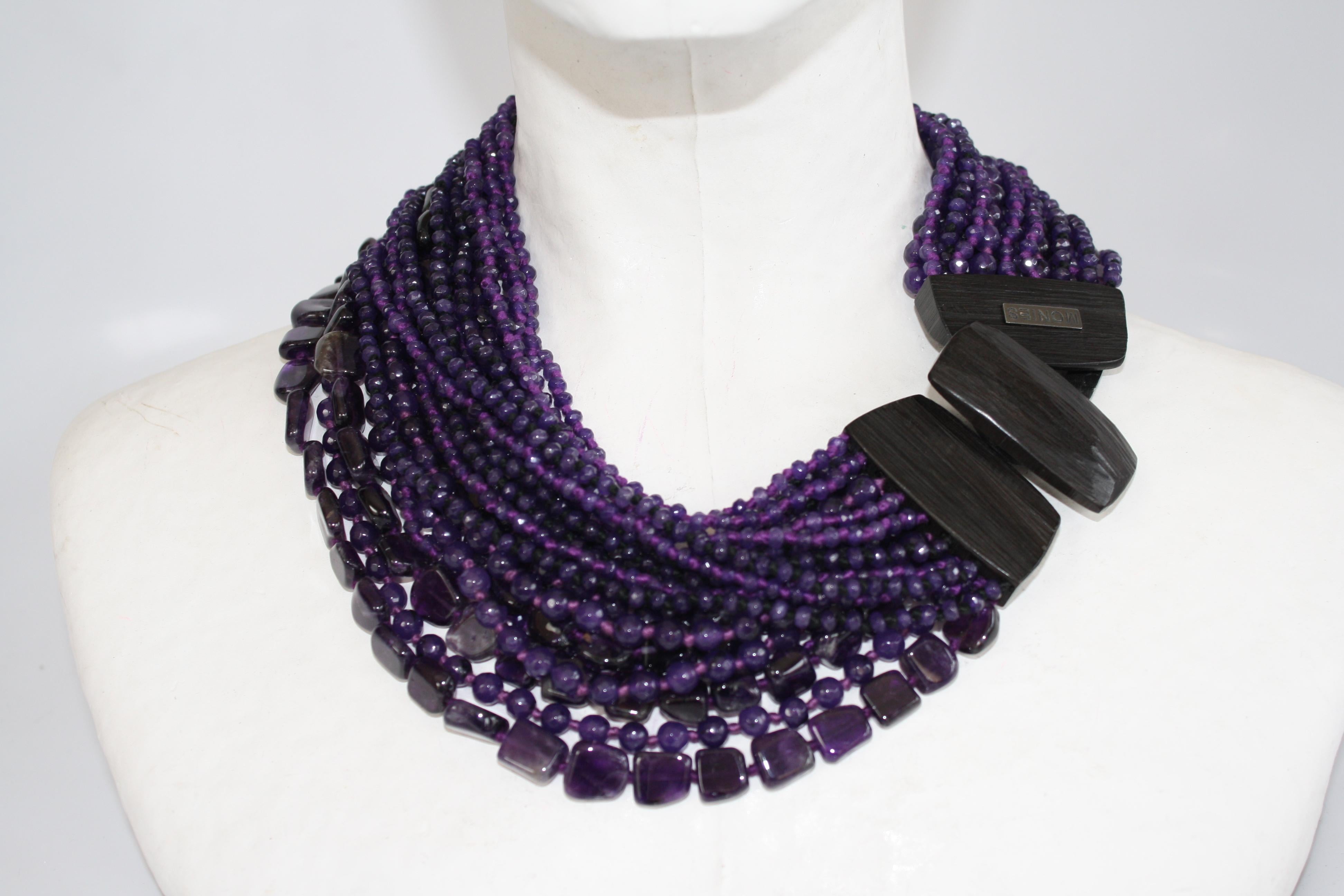Gorgeous strands of amethyst beads are connected to a fabulous ebony wood and leather closure in this statement necklace from Monies Denmark. 
