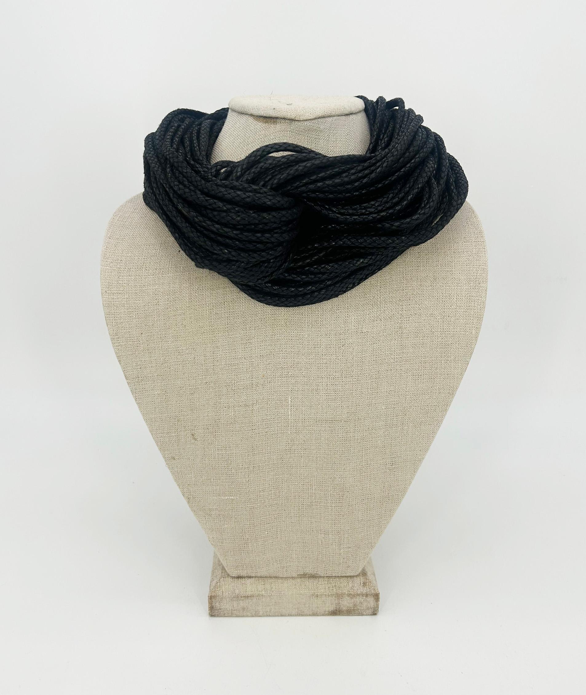 Collana girocollo in corda multipla intrecciata nera di Monies in ottime condizioni. Corda nera intrecciata a più fili con un design a due lati, con un'esclusiva cravatta a torciglione al centro e chiusura posteriore in resina magnetica nera. Un
