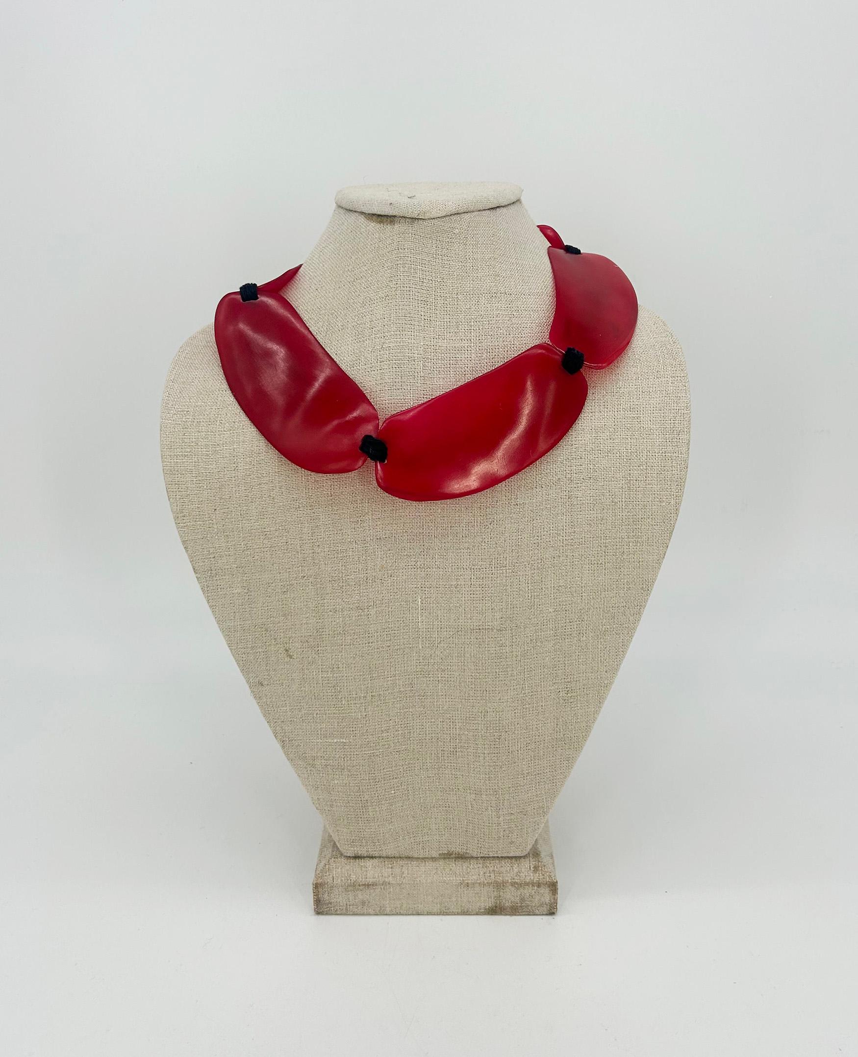 Monies Cherry Red Natural Resin Bead Black Leather Choker Necklace in very good condition. Cherry red resin beads in unique hand formed shape which curves naturally along the necklace and is strung together with black leather knots. Back loop and