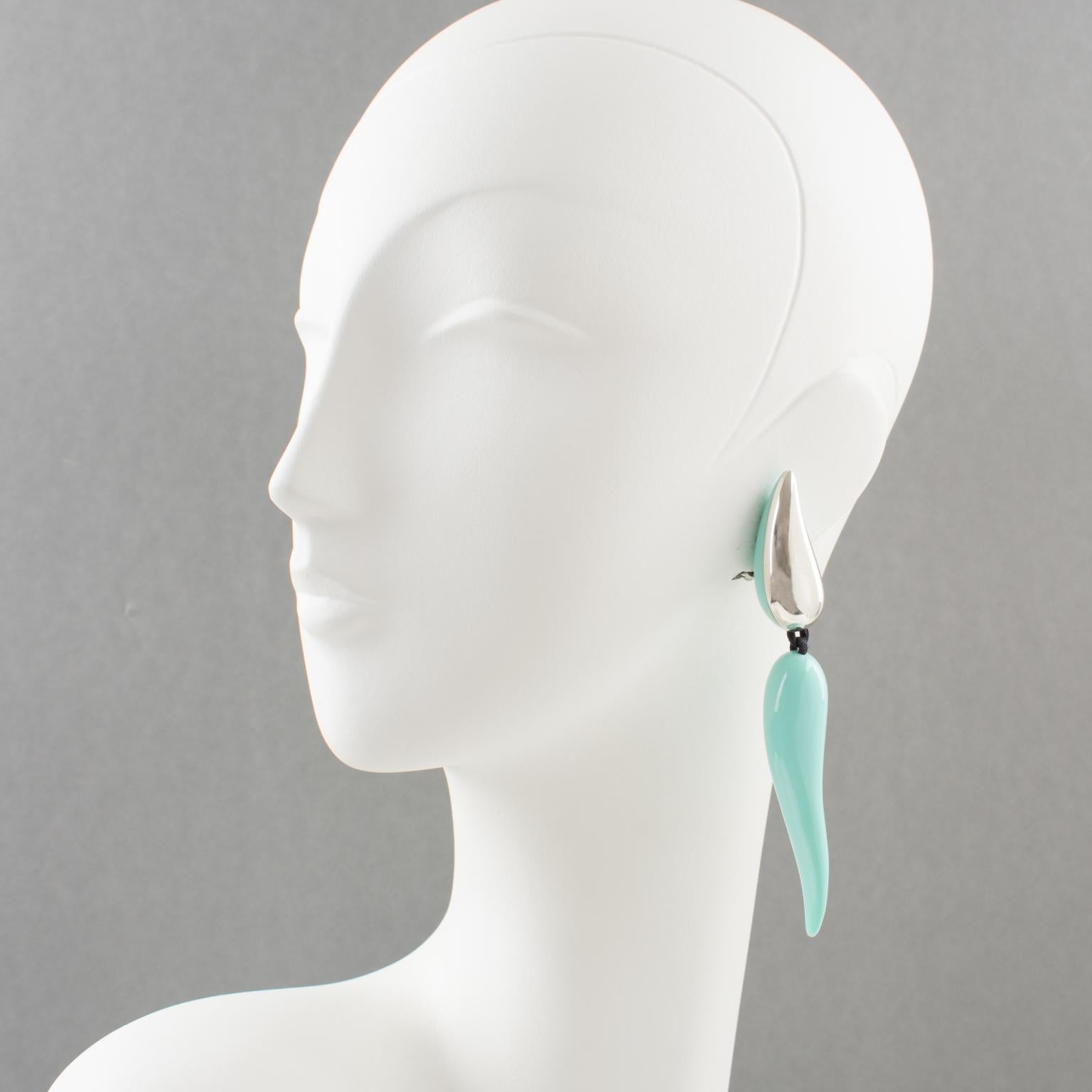 Thrilling oversized clip-on earrings by Gerda Lyngaard for Monies. Features an extra-long dangle shape in an organic-feel design in sterling silver contrasted with polar blue turquoise high gloss resin. Marked 