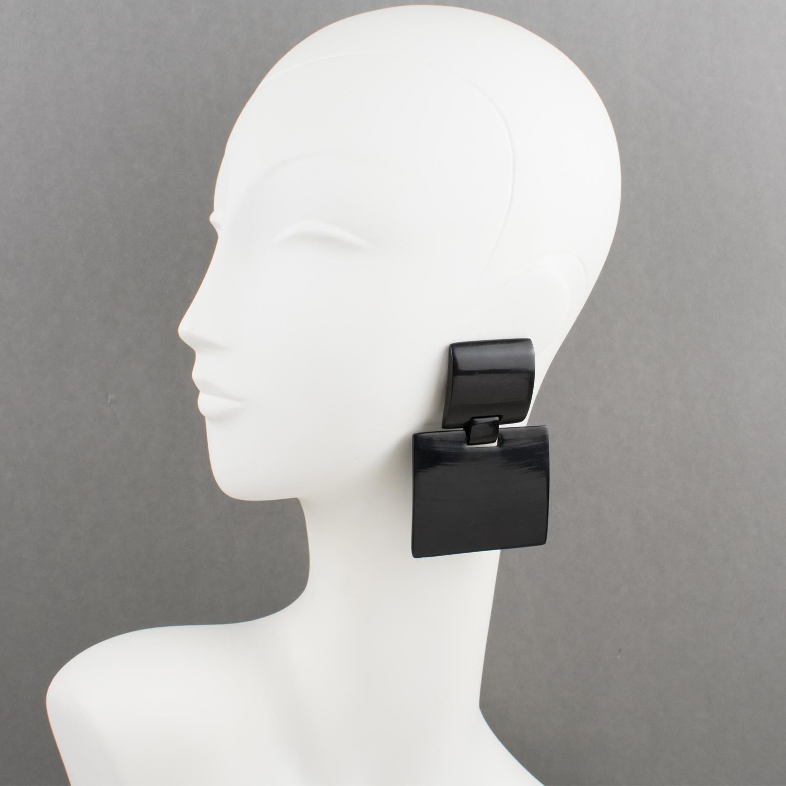 These gorgeous oversized clip-on earrings, designed by Gerda Lyngaard for Monies, feature a dangling geometric shape built with black Ebony wood. They have marked 