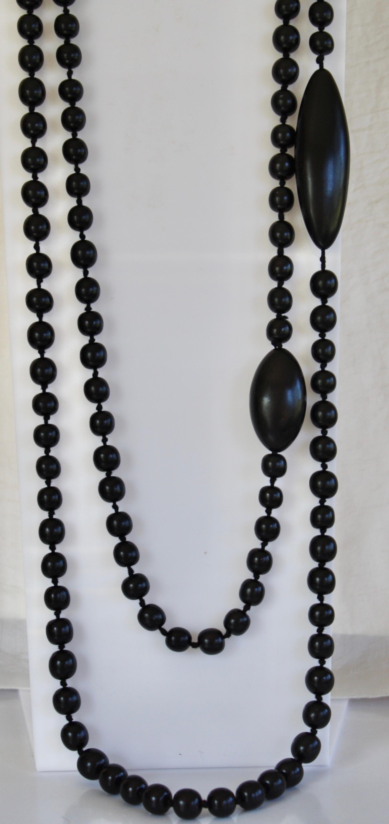 Long strand of ebony wood beads can be wrapped around multiple times to create layered effect. Made by Monies Denmark.