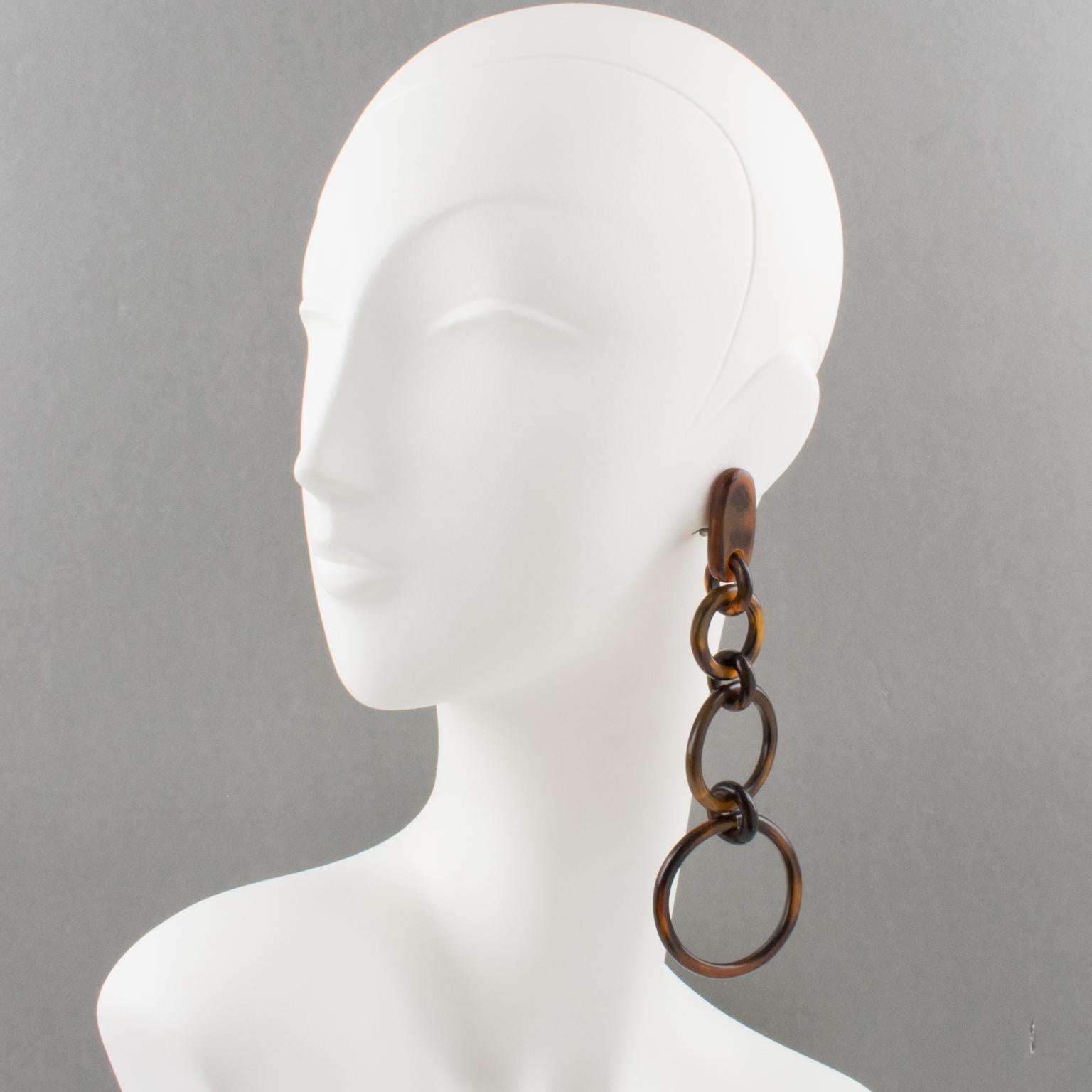 Beautiful oversized clip on earrings by Gerda Lyngaard for Monies. Extra-long dangling geometric shape, with three graduated rings in natural brown horn, in a very organic flair. Marked 