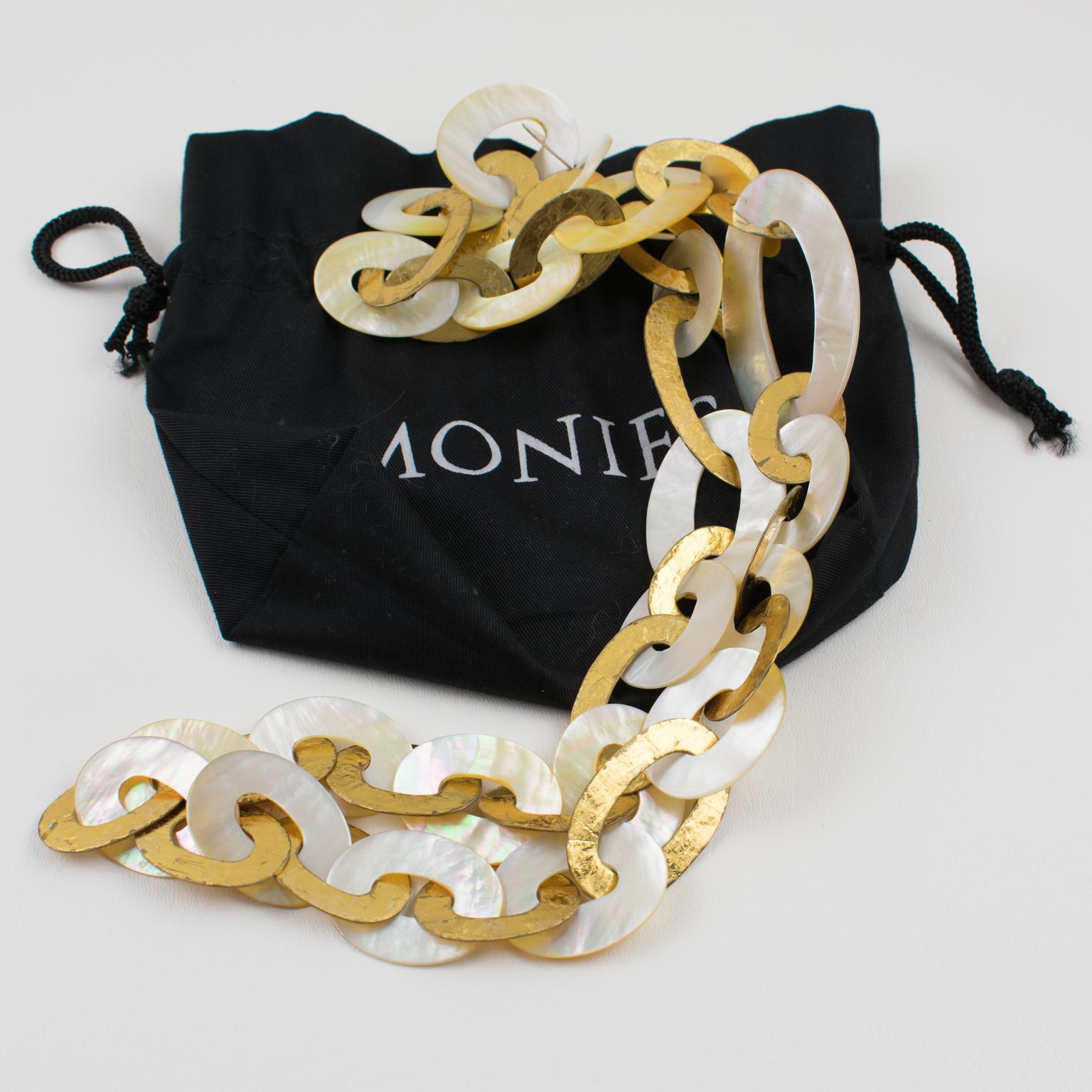 Questa sofisticata collana extra-lunga di Gerda Lyngaard per Monies presenta una forma dimensionale con elementi geometrici ovali a maglie piatte in metallo rivestito in lamina d'oro contrastati da elementi a maglie di conchiglie naturali che