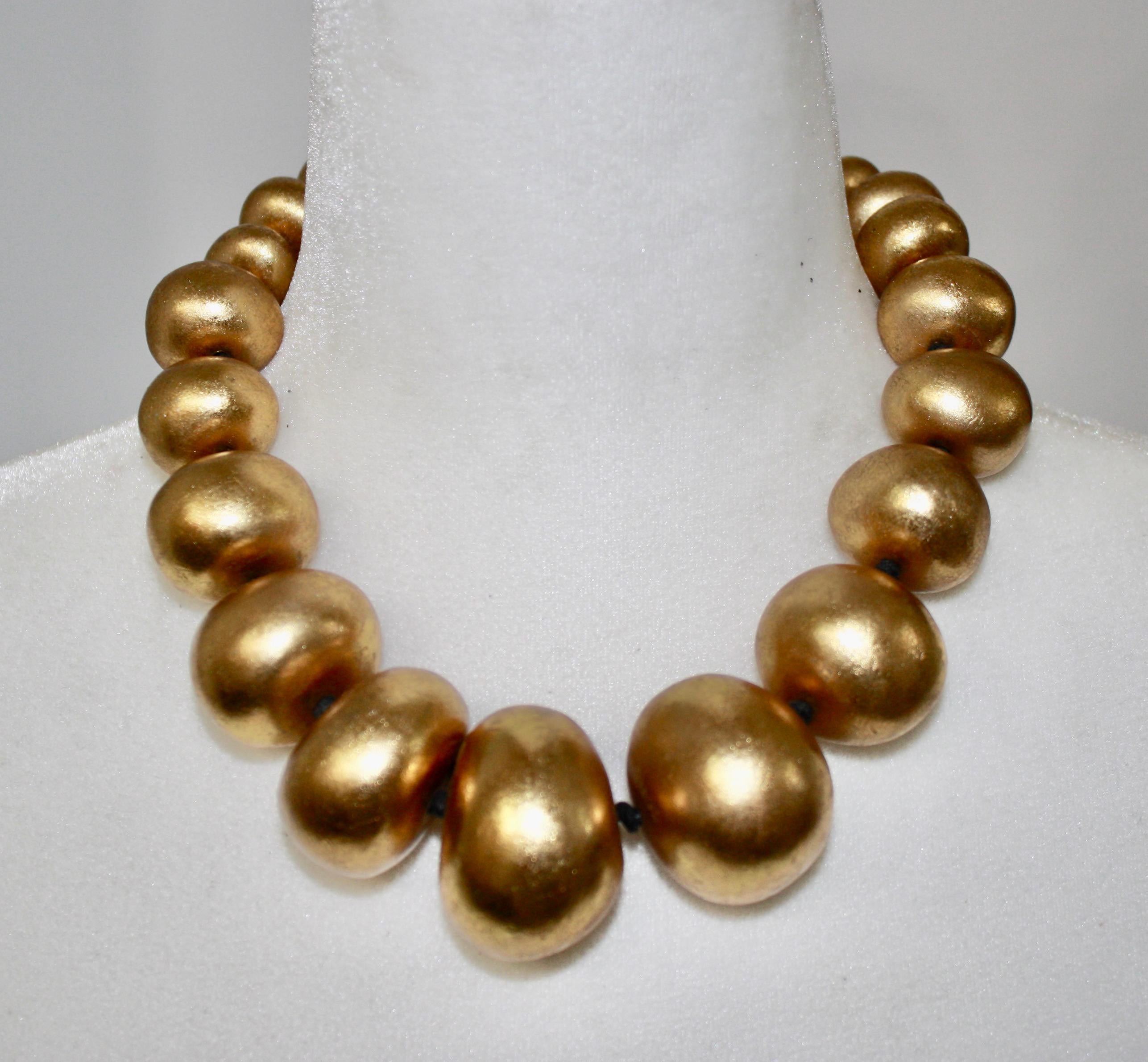 Gold tone wood beaded necklace with toggle clasp. Signature on clasp. A classic in monies collection