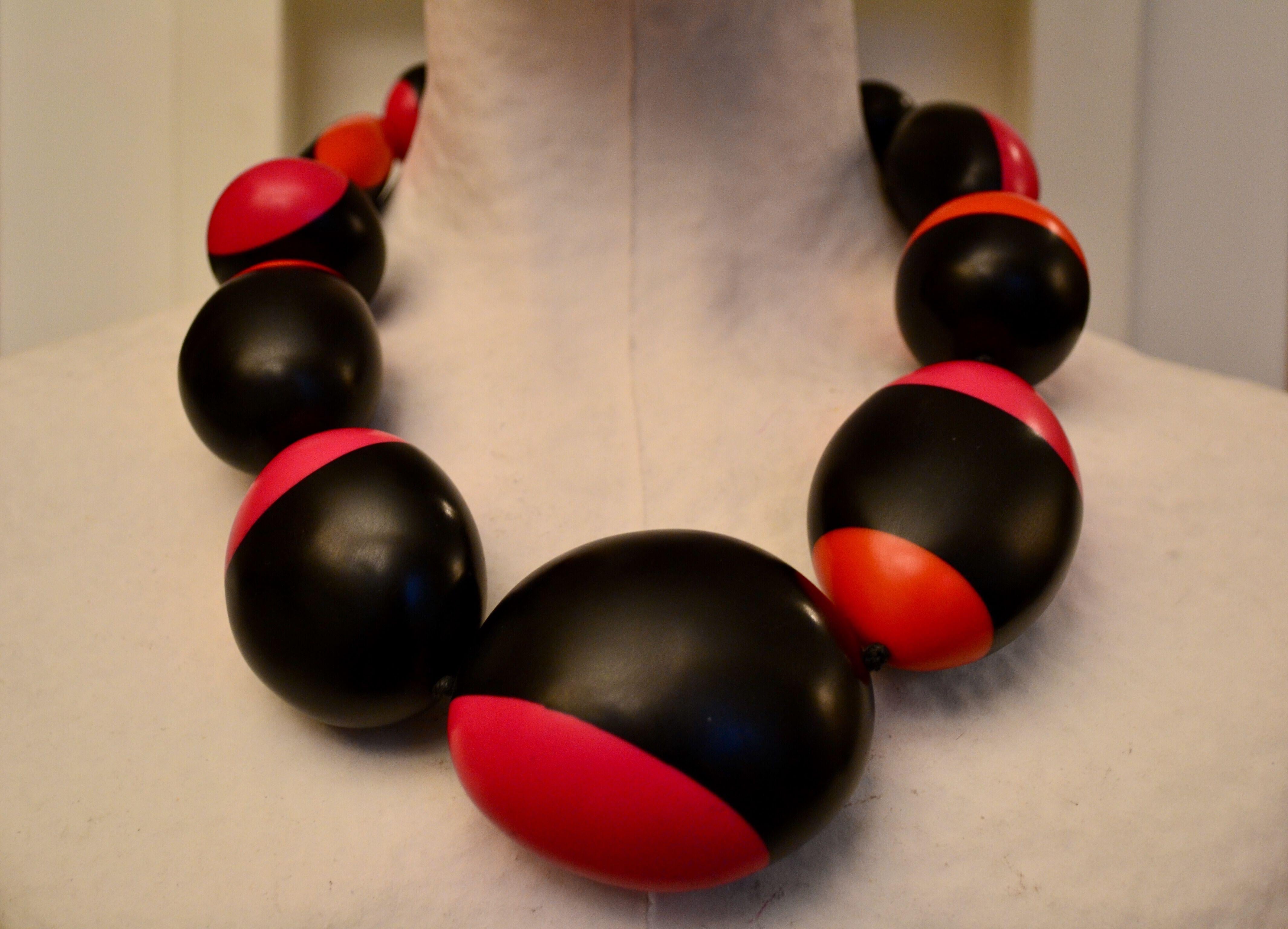 Polyester pebble necklace in pink, orange, and black from Monies Denmark. 