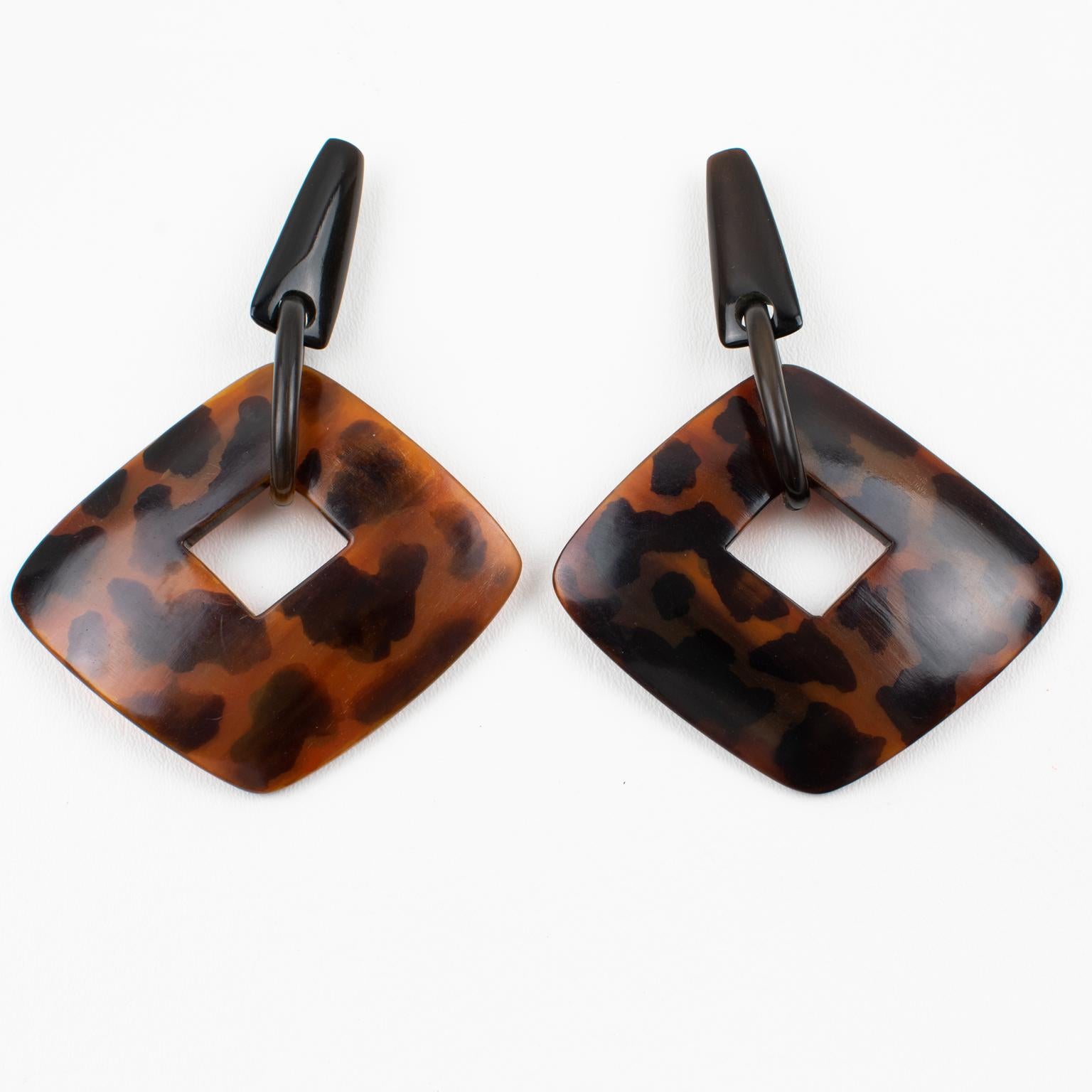 Questi rari e bellissimi orecchini a clip oversize di Gerda Lyngaard per Monies sono caratterizzati da una forma geometrica penzolante con un'enorme ciambella quadrata in resina tartarugata (tortoisehell) dal sapore molto organico. Le chiusure