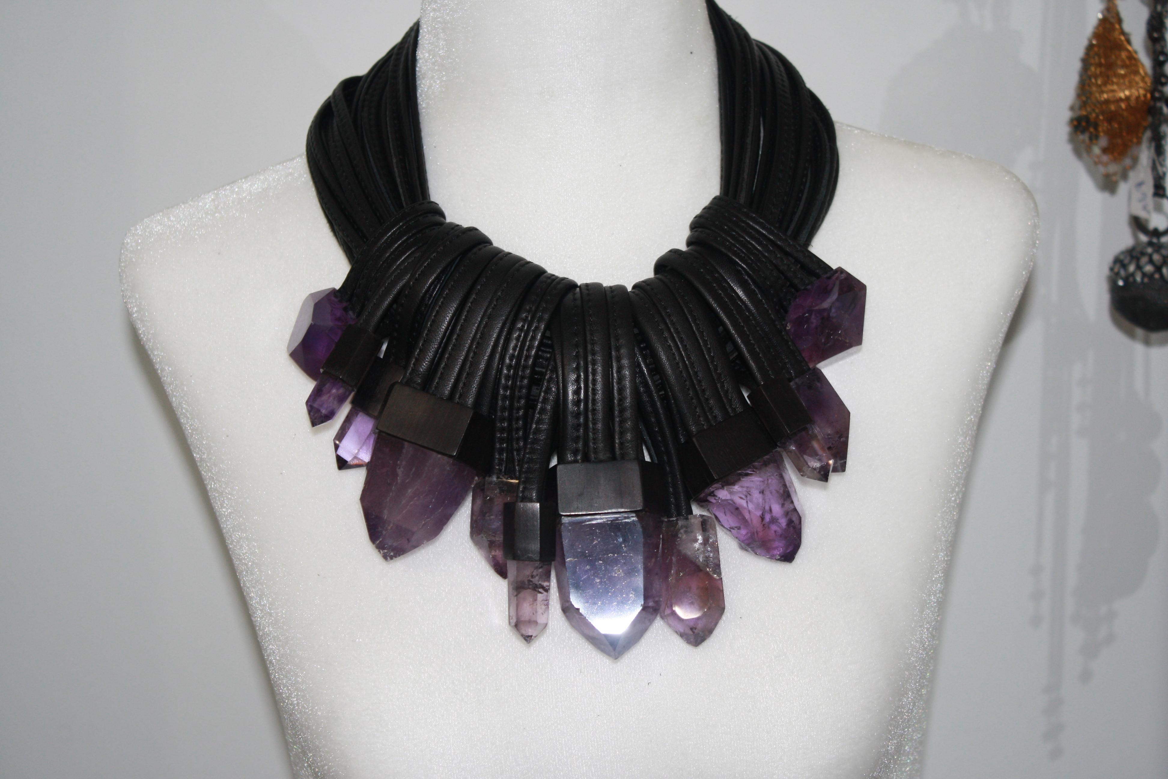 22 strands of stitched leather with  a toggle clasp lock in ebony. 12 pendants made of  octogonal shaped amethysts . This is an amazing one of a kind!