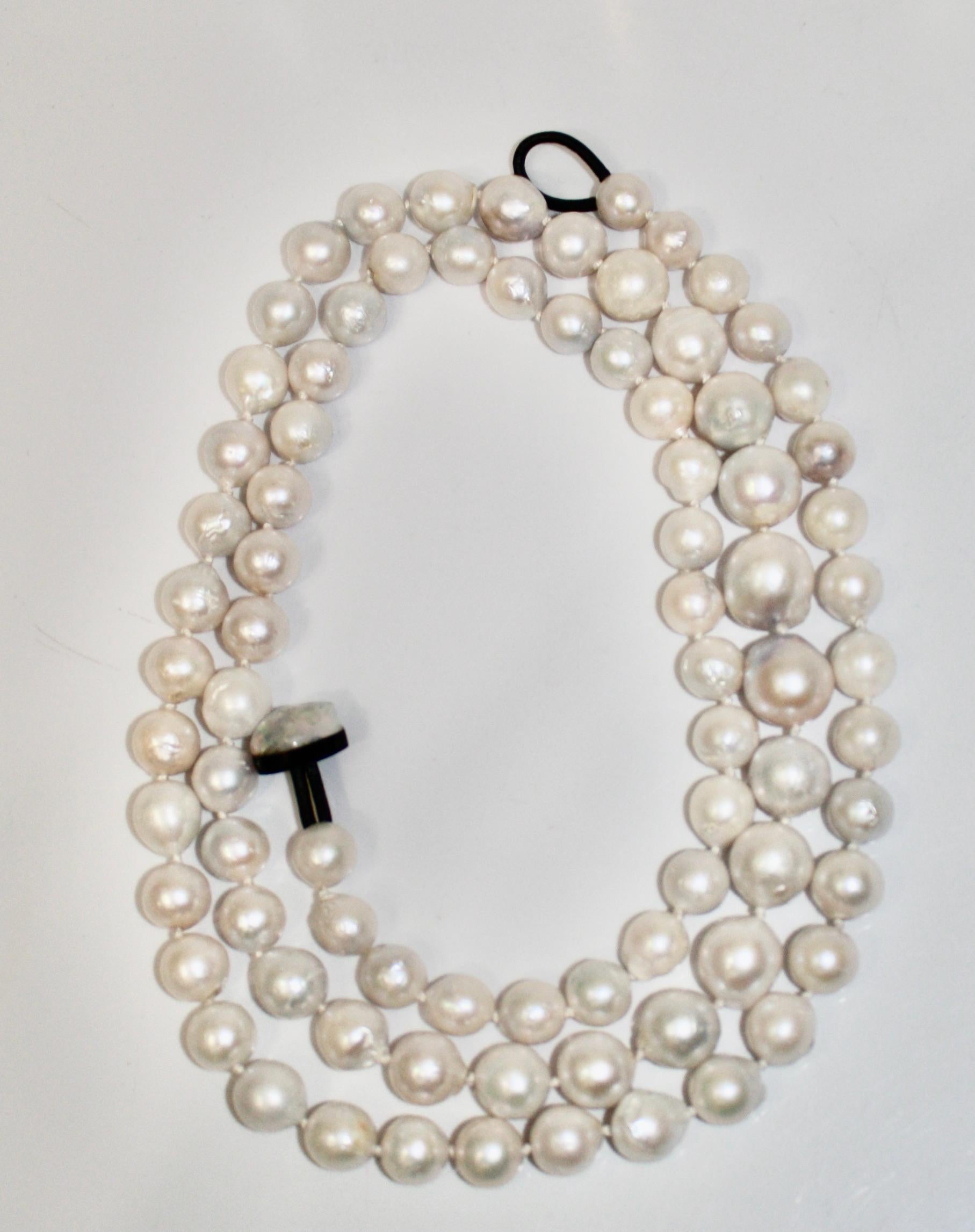 Pearl are threaded and knotted in gradual size. Clasp is made with horn and leather. Necklace can be wrapped around 3 times .