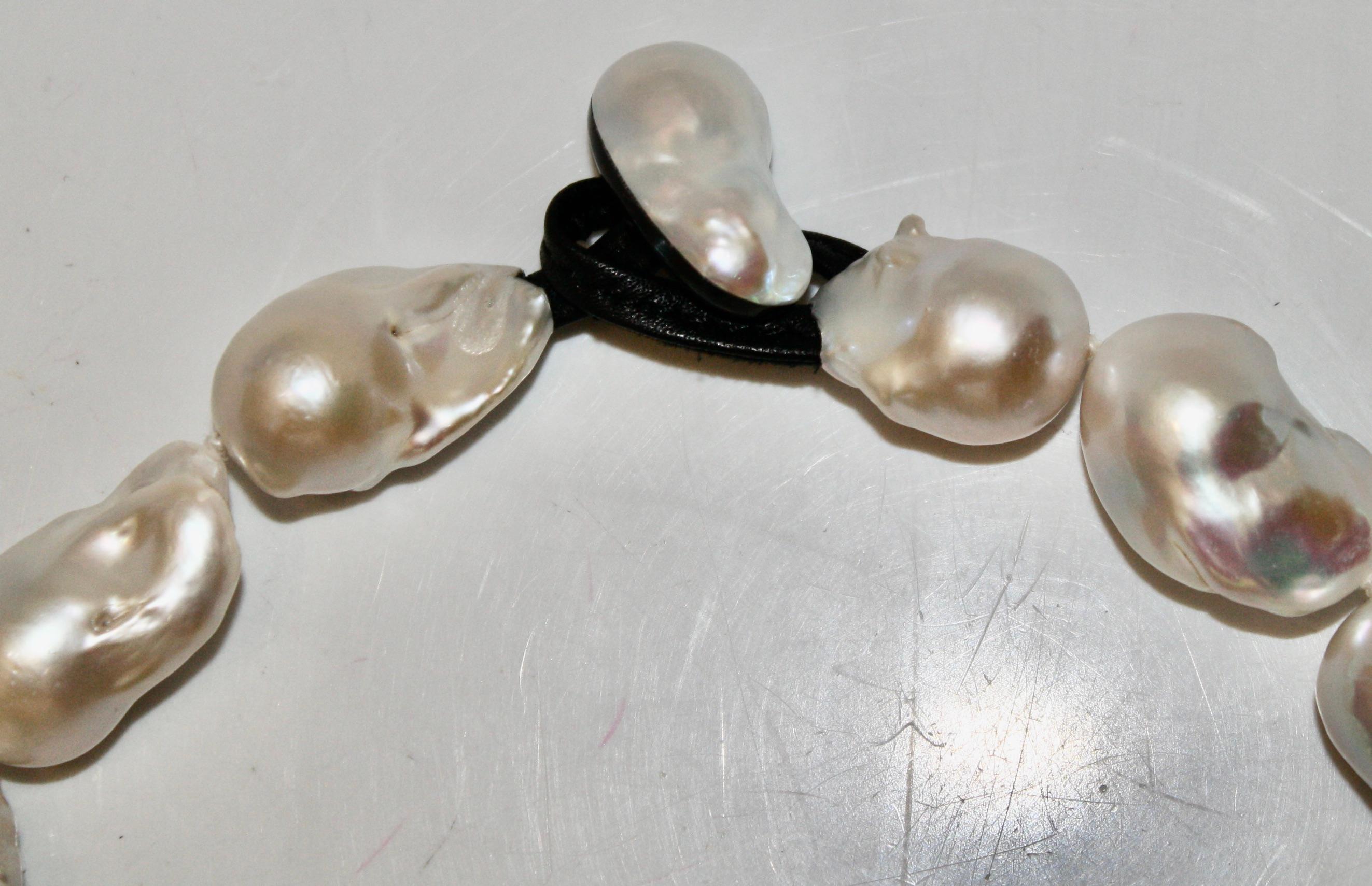 14 oversized baroque pearls knotted with a leather and ebony clasp. Signature on clasp. Pearl length vary from 1” to 1.5”.
MONIES IS A DANISH JEWELLERY COMPANY FOUNDED IN 1973 BY GERDA AND NIKOLAI MONIES. ALTHOUGH BOTH ARE CLASSICALLY TRAINED