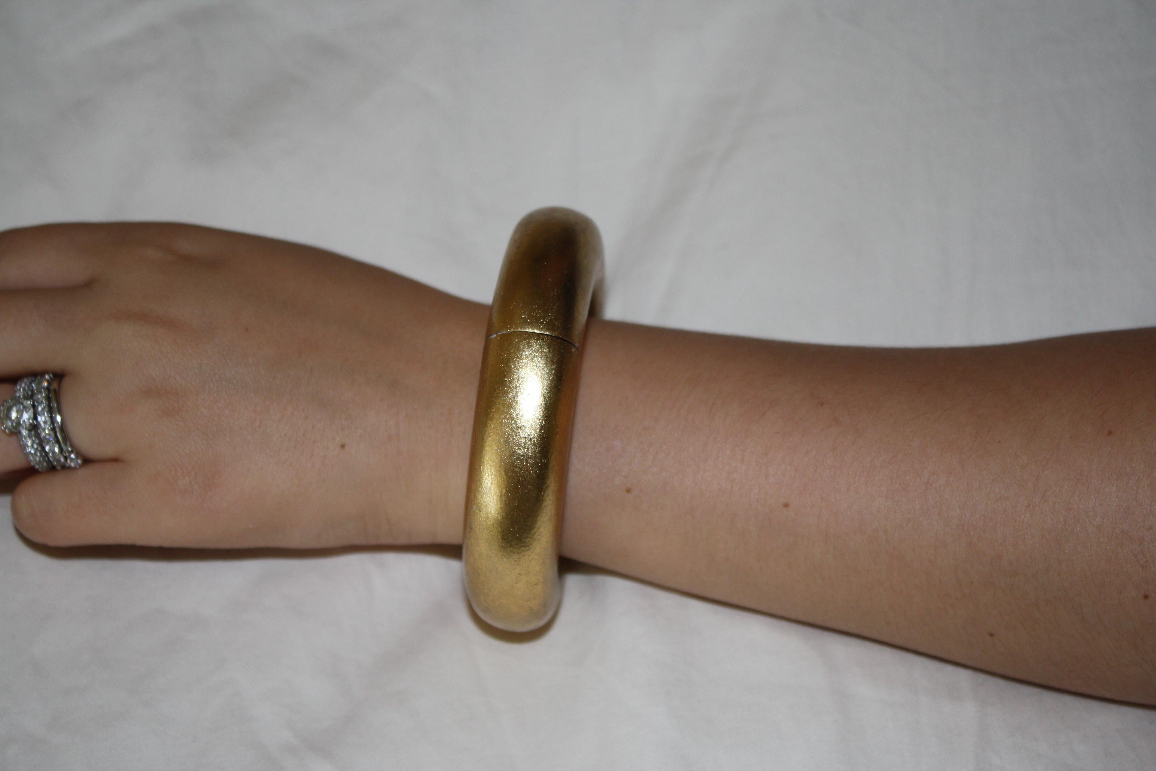 Statement bangle in gold leaf from Monies Denmark. These bangles are awesome because they have an elastic interior making it possible to get on and off despite the size of your hand. 

circumference 3.5” - inside 2.5”