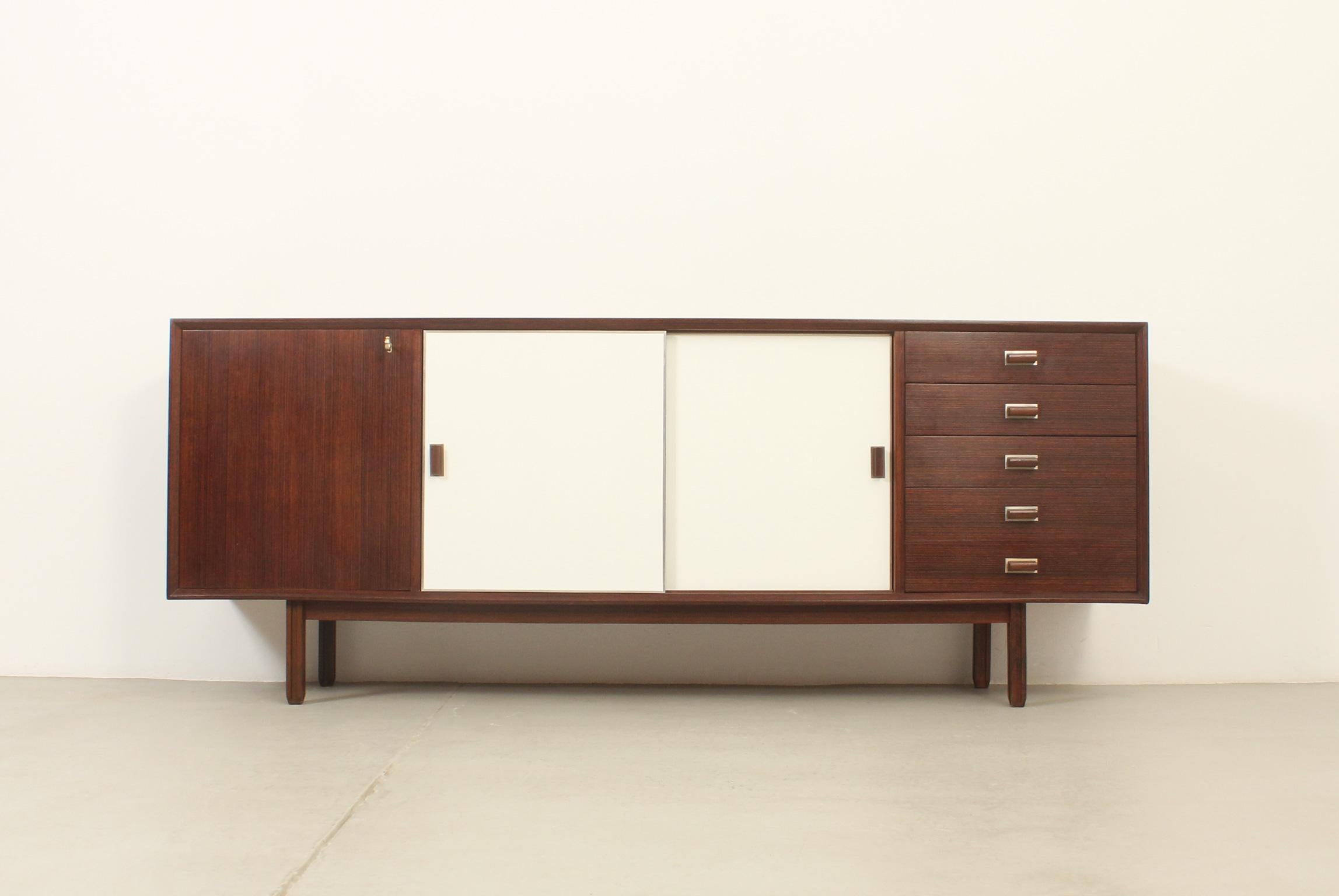 Sideboard model Monika designed in 1960's by George Coslin for Faram, Italy. Wenge and beech wood with laminate sliding doors. Five drawers and three doors with interior shelves. 