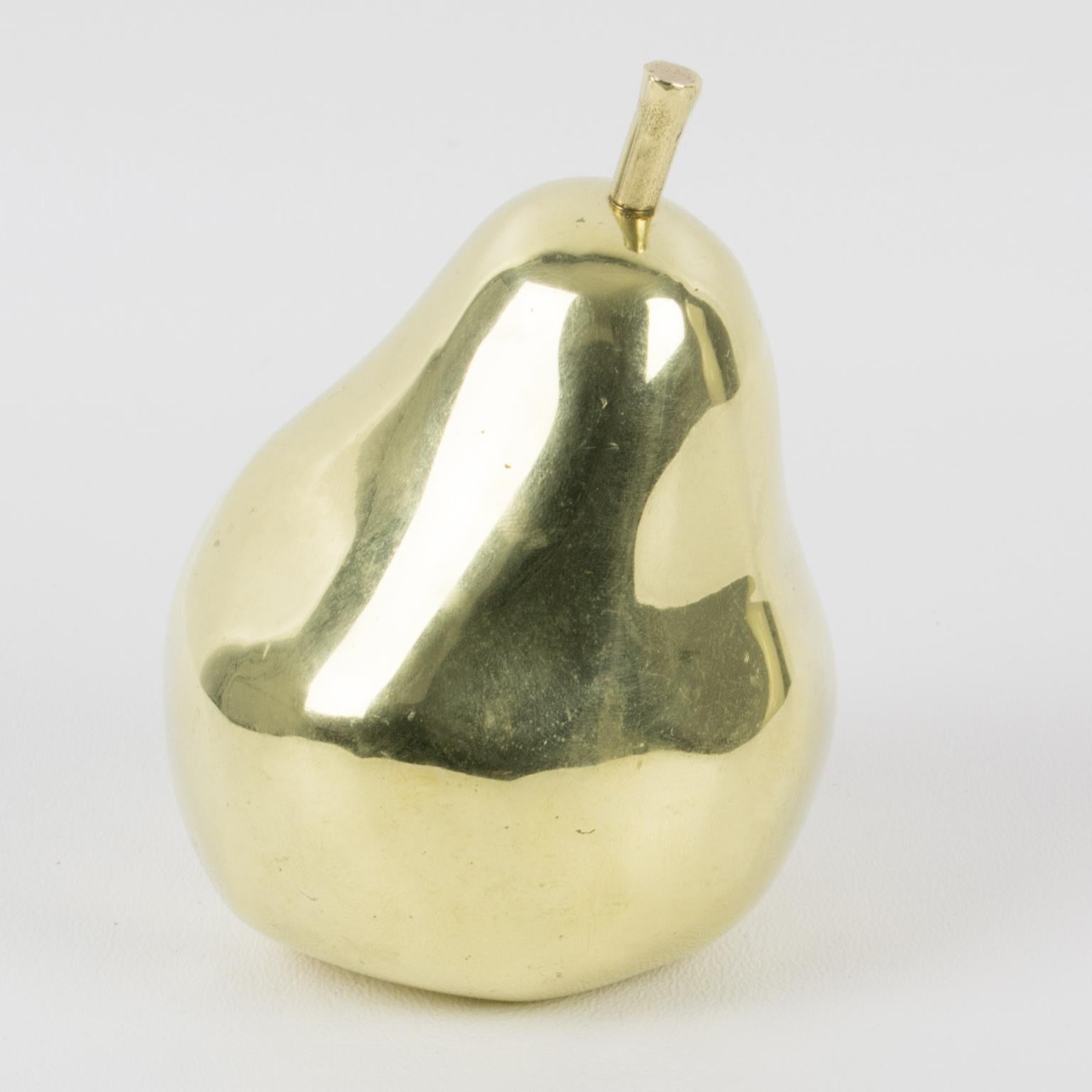 This stunning carved metal sculpture was hand-crafted by French sculptor Monique Gerber (France - 20th Century). The pear is rendered to its actual size in polished gilded bronze material. There is an engraved 