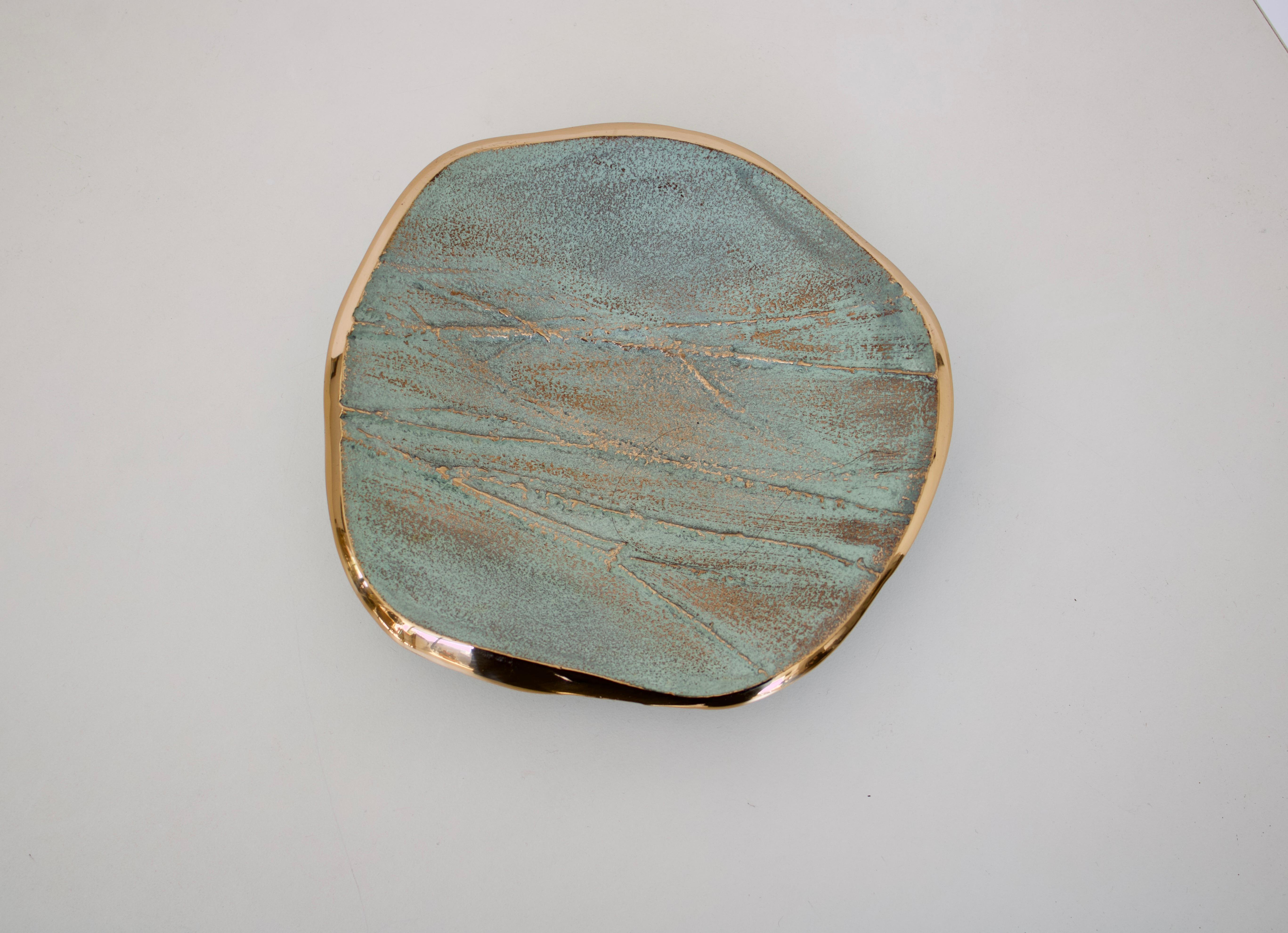 French low relief bronze dish or vide poche designed by French designer Serge Mansau for Monique Gerber in the Stratos collection with a variety of patina and polished edge. He was a famous French sculptor and creator of more than three hundred