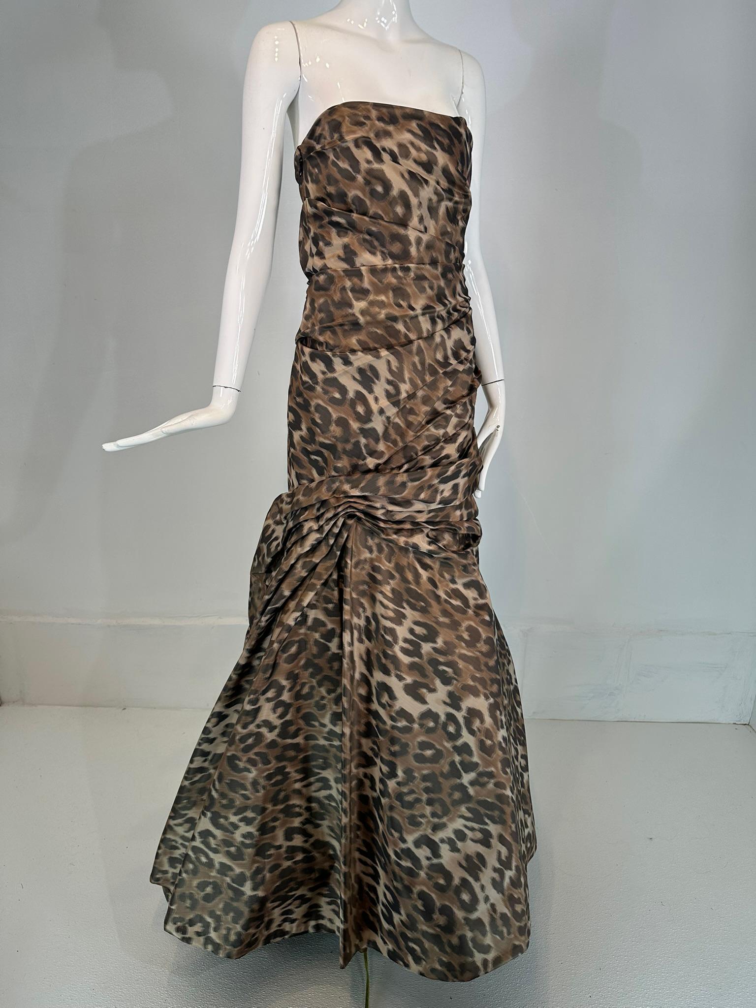 Abito da sera Monique Lhuillier Autunno 2011 senza spalline con stampa leopardo, drappeggiato e con corsetto, taglia Large.
Il corpetto aderente senza spalline con corsetto interno disossato è drappeggiato sul davanti e sulla schiena, la gonna è