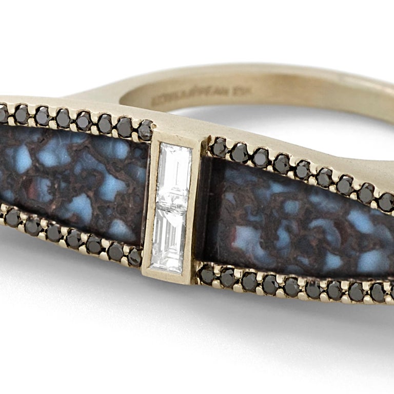 Blue-black fossilized dinosaur bone, white diamond baguette and black diamond navette arch ring, 18K recycled white gold, 0.58 TCW

This painterly blue specimen of fossilized dinosaur bone is accented by  black diamond pavé that traces the outline