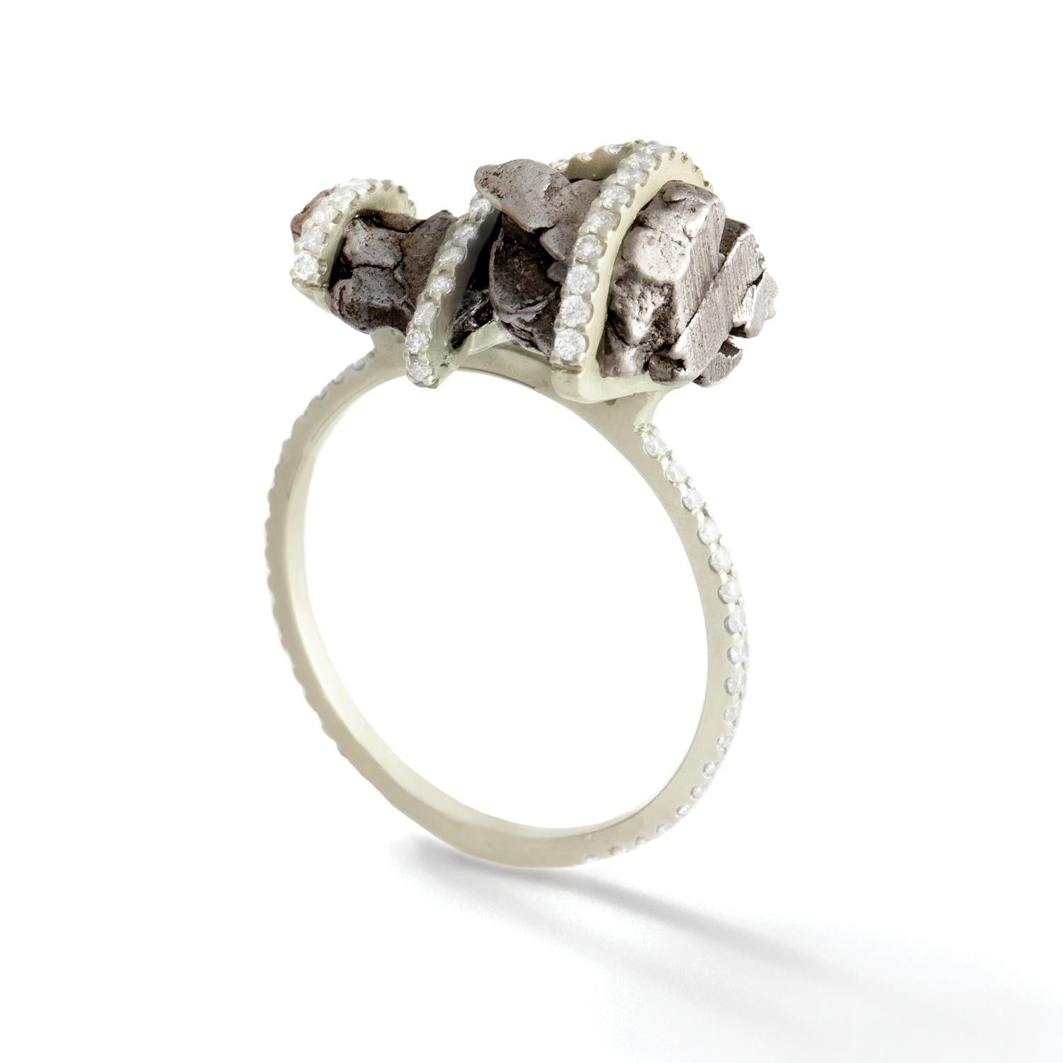 Sikhote-Alin meteorite specimen and white diamond ring, 18 carat recycled white gold, 0.61 TCW

Inspired by the intersection of Earth and Cosmos, this ring encages a natural undulating specimen of meteorite in a frame of white diamond pavé
