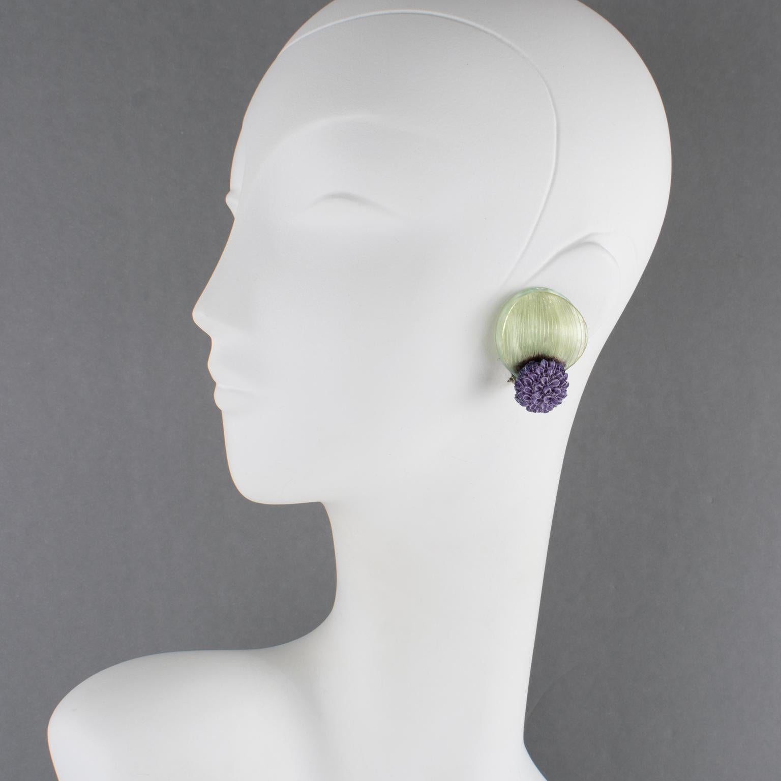 Ces rares boucles d'oreilles clipsables en talosel ou en résine de Monique Vedié présentent une forme de fleur stylisée et dimensionnelle de couleur violet lavande et vert aqua avec des détails texturés. Comme toutes les pièces vintage de Vedié, il