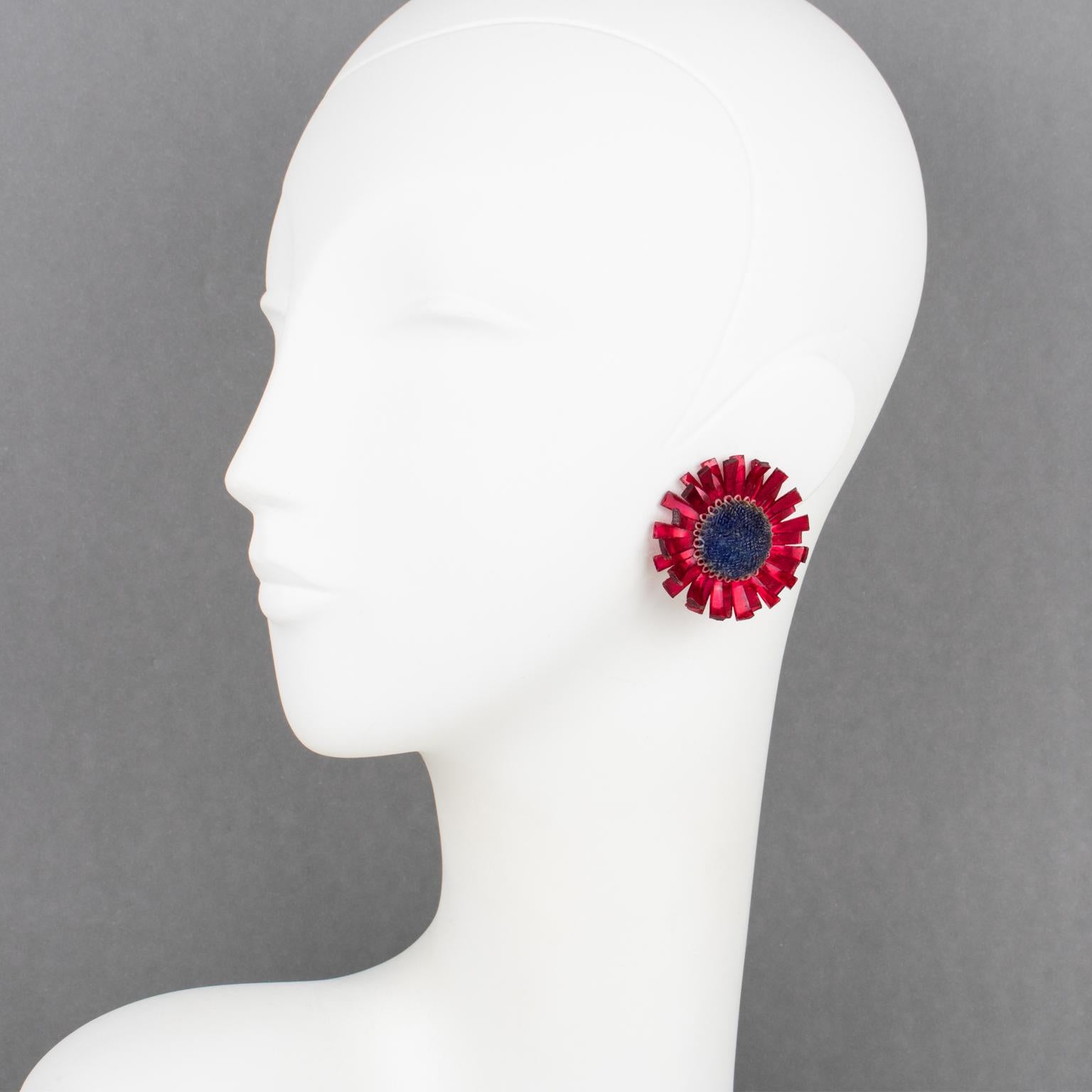 Ces exquises boucles d'oreilles Monique Vedie en résine ou Talosel à clip présentent une fleur en forme de chardon sculptée avec un motif texturé de couleur rouge carmin lumineuse et perlée contrastant avec un cœur texturé bleu marine. Ils sont