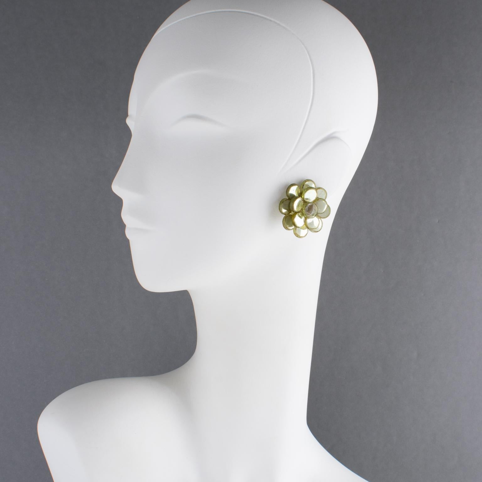 Ces superbes boucles d'oreilles à clip de Monique Vedie (1924-2021) en résine ou en talosel présentent une forme de fleur géométrique stylisée avec un design dimensionnel sculpté, complété par une belle couleur vert amande clair et des inserts