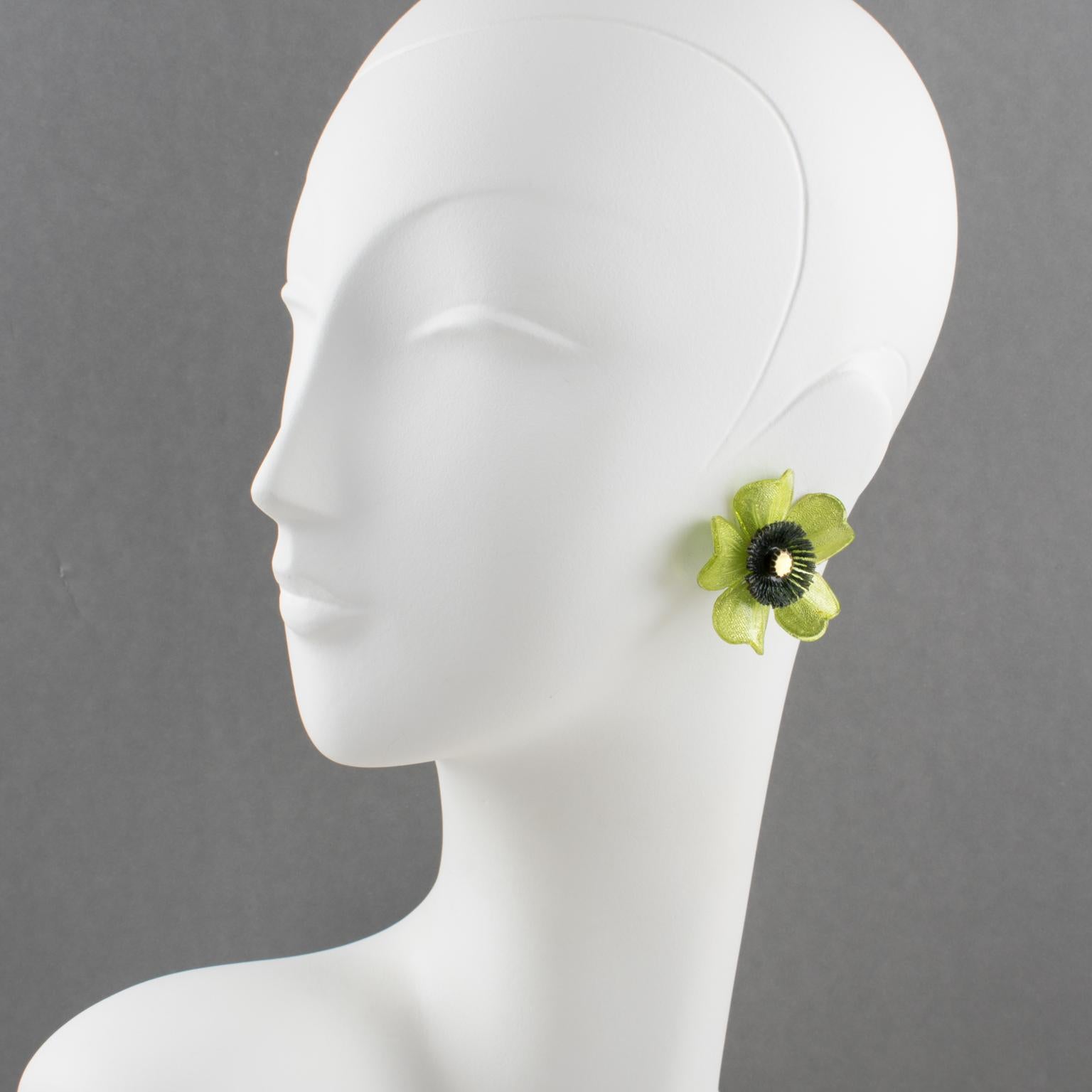 Lovely Monique Vedie resin or Talosel clip-on earrings. Features a daisy flower shape with a carved dimensional design complimented with a textured pattern in glittering pistachio green and black colors with a tiny mirror heart. French clip