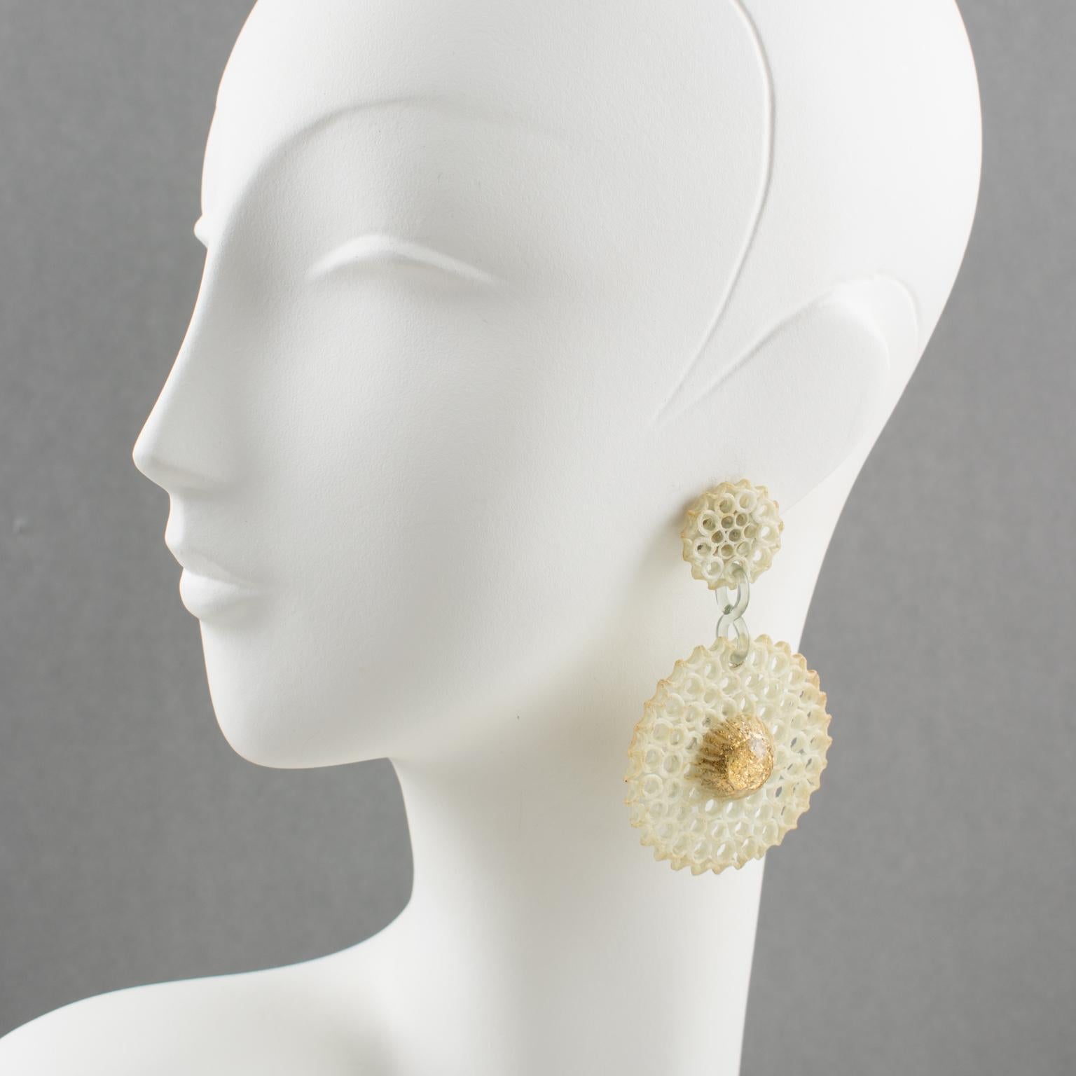 Refined Monique Vedie Talosel or resin clip-on earrings. Featuring floral dangling shape with a large disk with a textured pattern and see-thru carving like a sort of lace in an off-white color, topped with dimensional transparent resin cabochon