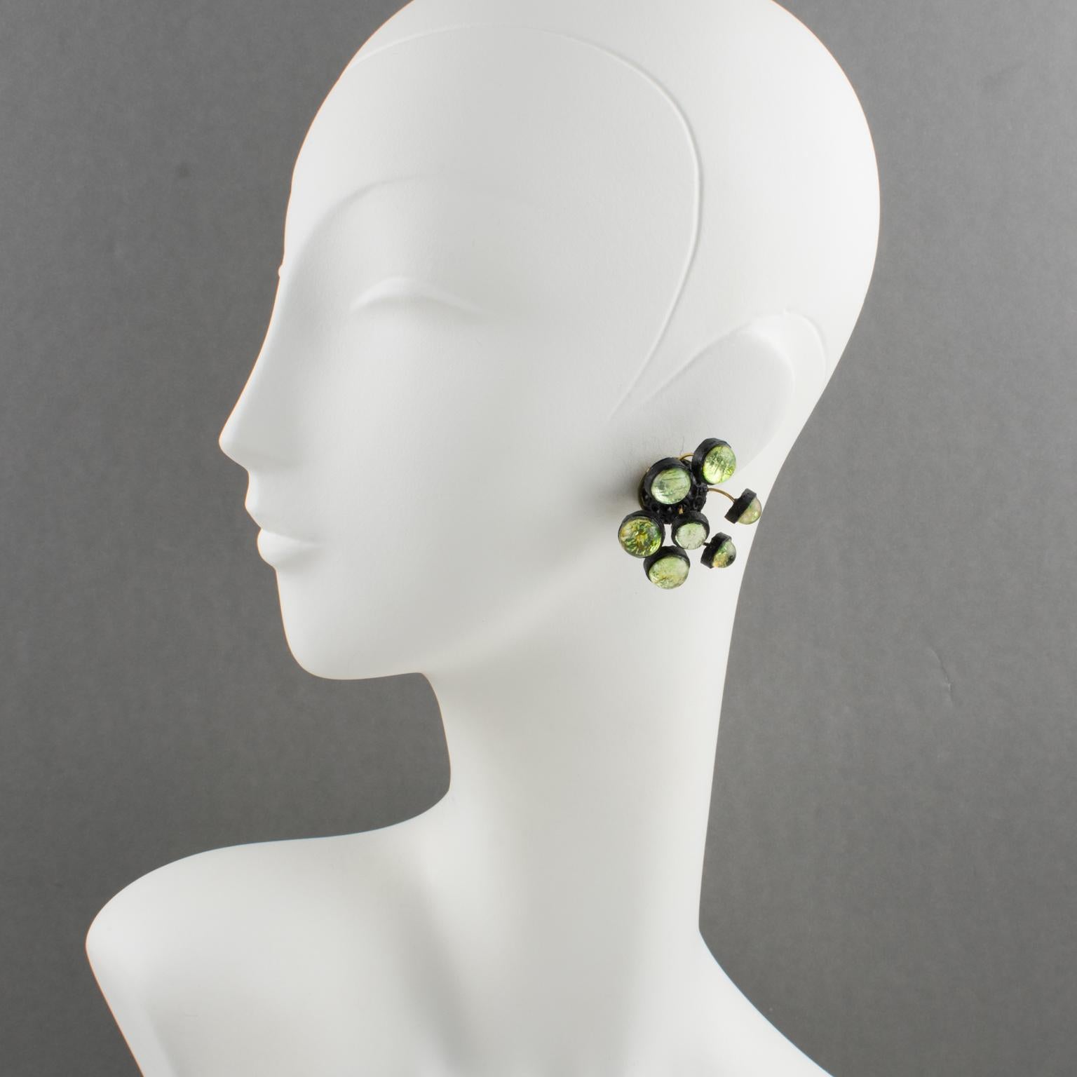Stunning French Jewelry Designer Monique Vedie Paris clip-on earrings. Dimensional shape with sputnik-inspired design, in black resin or Talosel, topped with green resin cabochons. Monique Vedie vintage resin jewelry is always