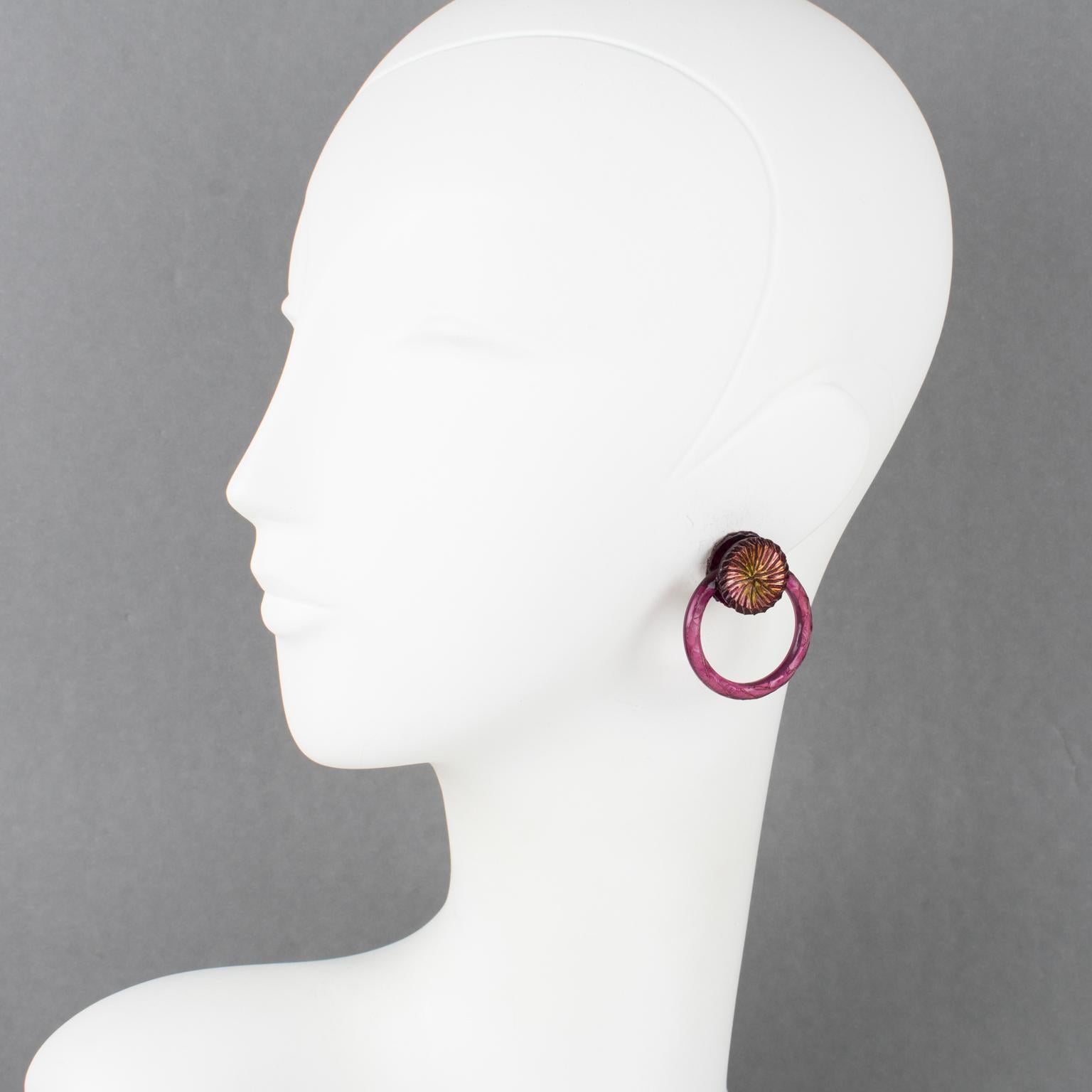 Superbes boucles d'oreilles à clip de la créatrice de bijoux française Monique Vedie Paris. Forme dimensionnelle avec un motif de heurtoir sculpté, en résine violette framboise ou Talosel, avec des reflets iridescents. Les bijoux vintage en résine