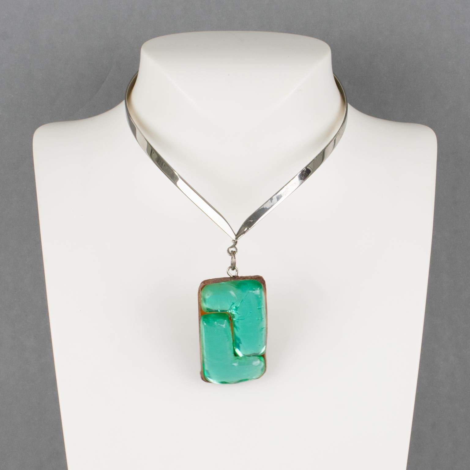 Questa splendida collana girocollo della designer di gioielli francese Monique Vedie Paris è caratterizzata da una maglia rigida intorno al collo in metallo cromato ornata da un ciondolo a forma di talosella modernista verde turchese su sfondo