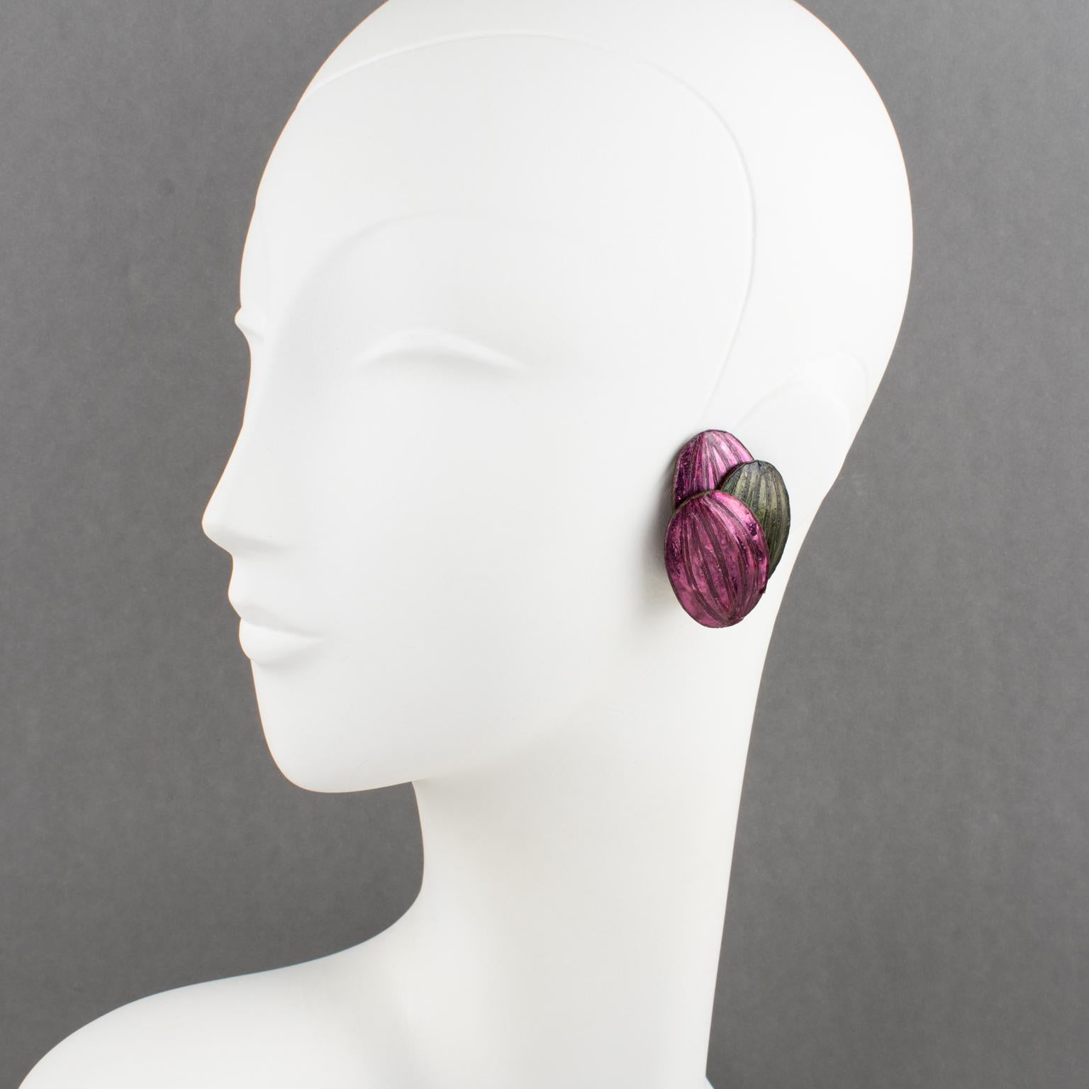 Estos raros pendientes de clip de resina o Talosel de Monique Vedié presentan una estilizada forma de flor dimensional en púrpura y verde nacarados. Como todas las piezas vintage de Vedié, no hay marca visible del fabricante.
Los pendientes están en