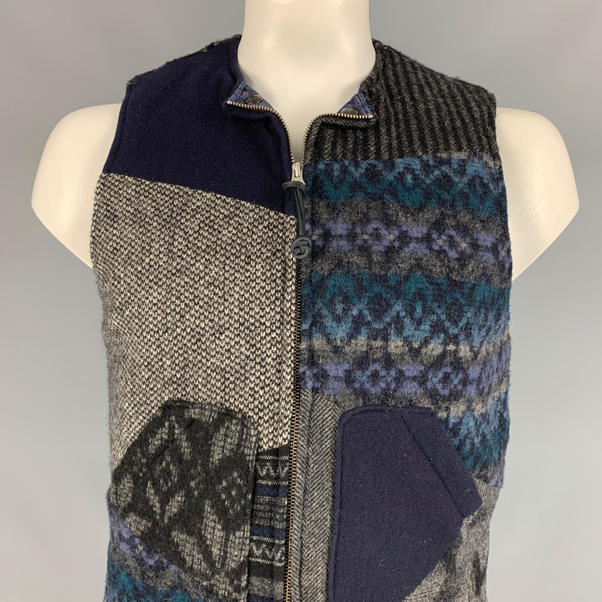 MONITALY vest comes in a navy & grey patchwork wool blend with a full liner featuring snap button details, patch pockets, and a full zip up closure. Made in USA. 

Very Good Pre-Owned Condition.
Marked: 42

Measurements:

Shoulder: 15 in.
Chest: 42