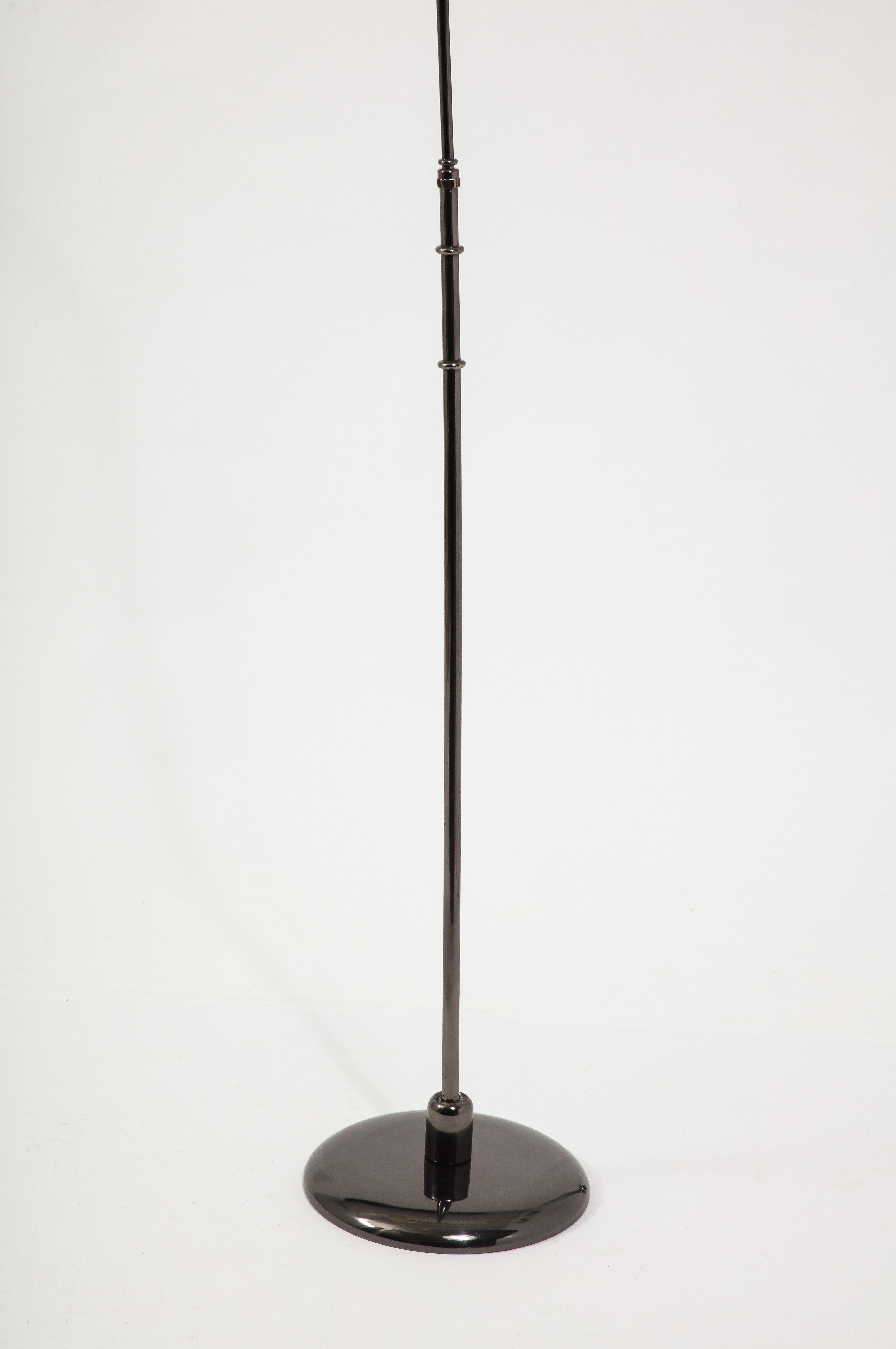Black nickeled adjustable floor lamp, the base can be angled in any direction, the stem telescopes and the head is on a swivel.
