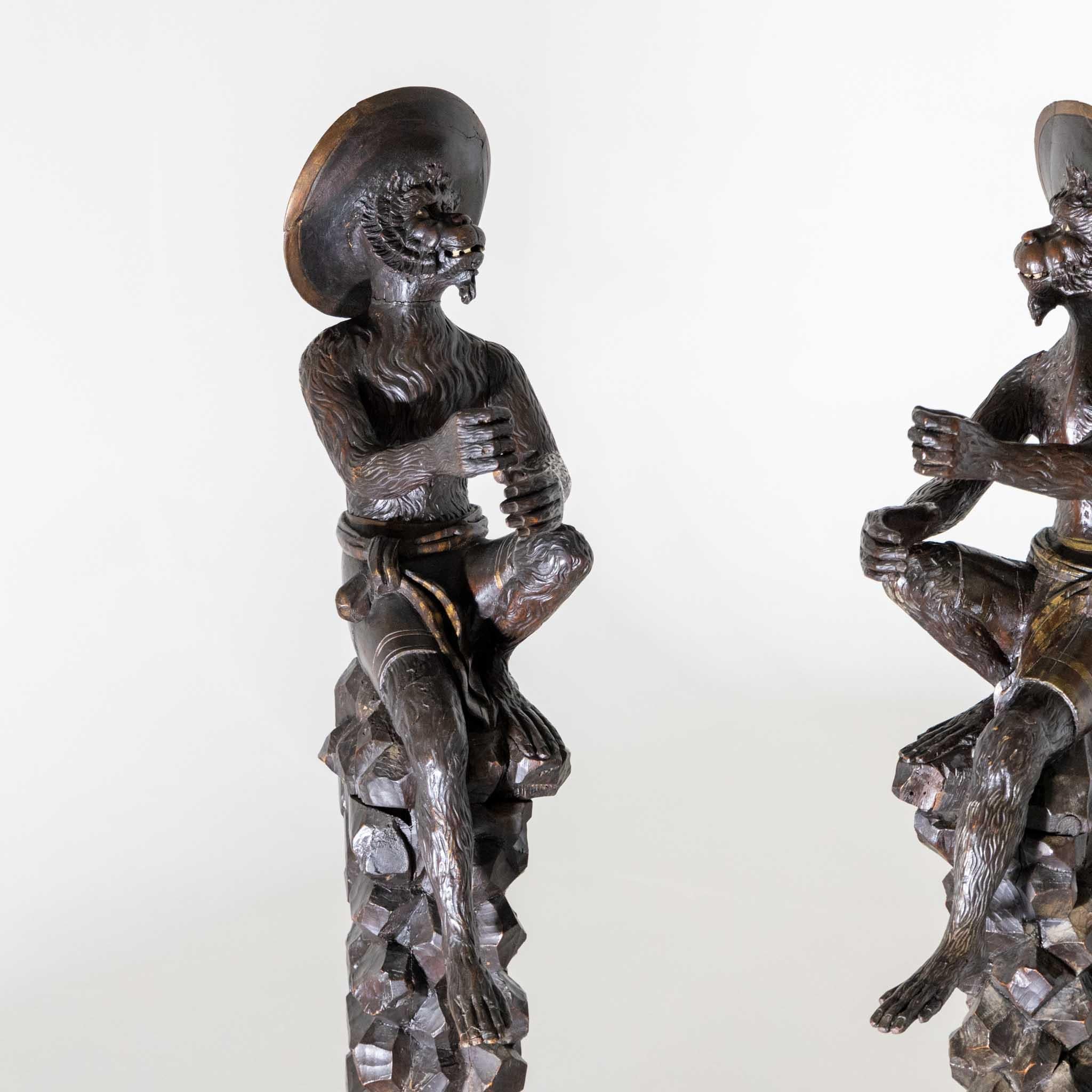 Pair of monkey figures carved from walnut as torchbearers. The monkeys in Venetian costume are sitting on high stylised rocks and are designed in the same way.