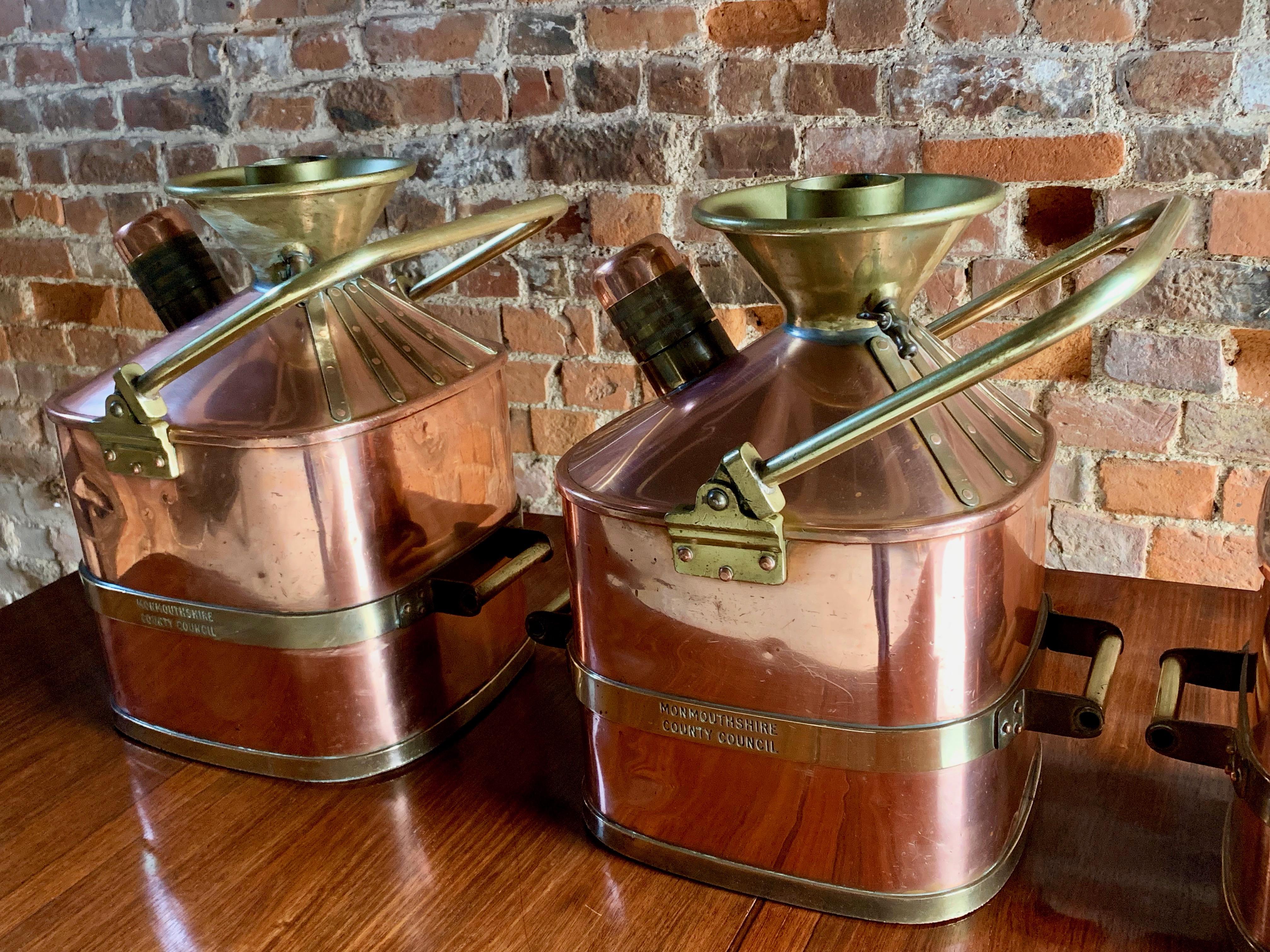 A stunning and extremely rare set of five copper and brass imperial measure petrol cans for Monmouthshire county council weights and measures department, petrol measures comprising five, four, three, two and half gallon examples, each with