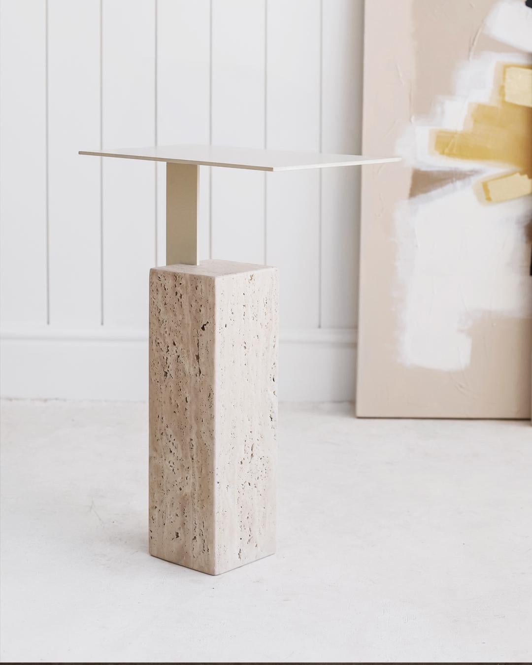 The Mono side table has a thin rectangular top which lays elegantly on a thick stone pedestal, creating the appearance that it’s floating on air. The table's slim silhouette, elegant proportions and dramatic texture make it suitable for almost
