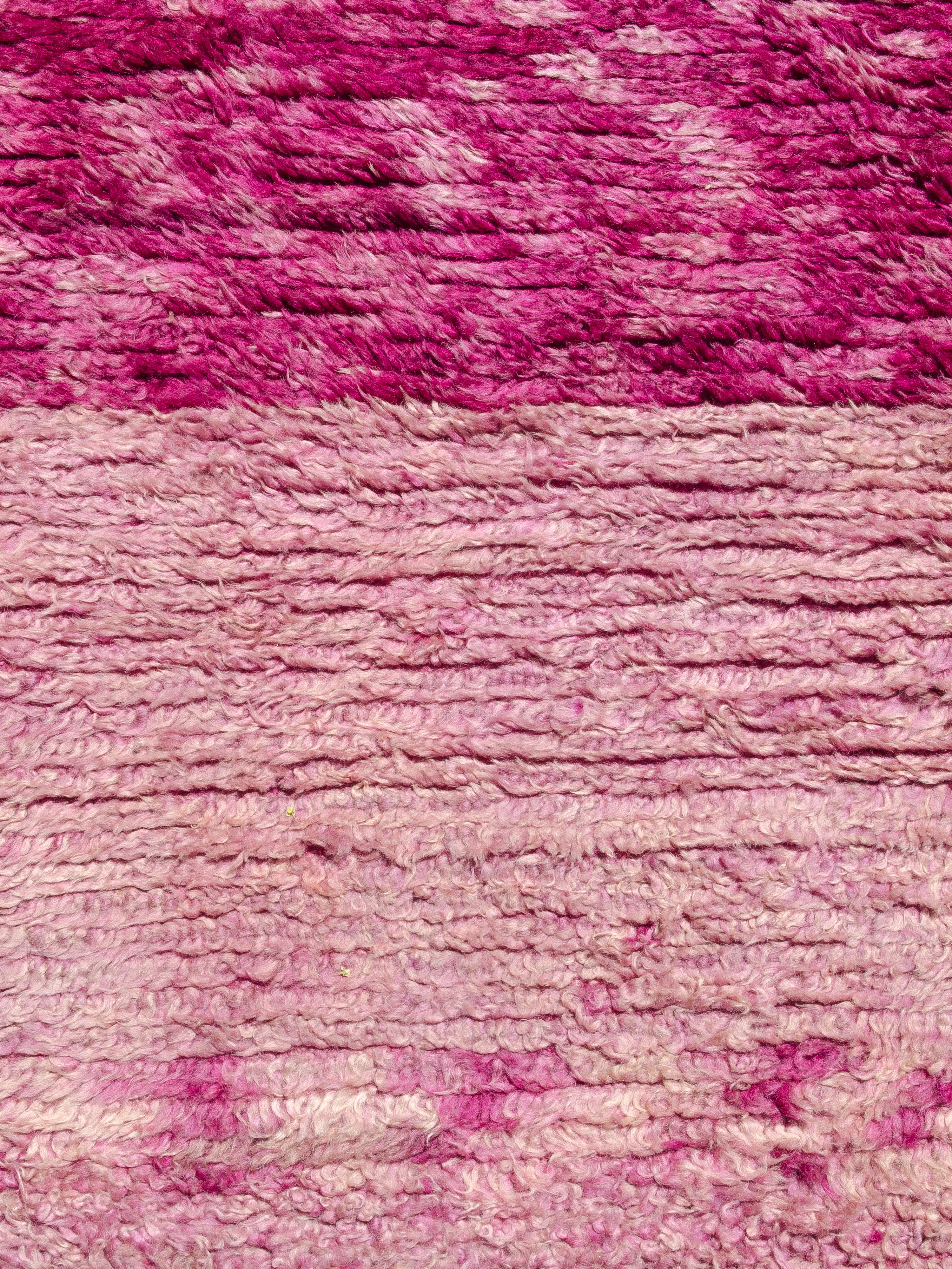 Dieser minimalistische und doch auffällige Vintage-Teppich von Beni M'Guild zeigt ein Farbfeld ohne Motive. Geknüpft in einem abgewetzten Magenta und Rosa, mit einer Verschiebung der Farbsättigung in der Nähe der Spitze des Stücks. 100% Wolle mit