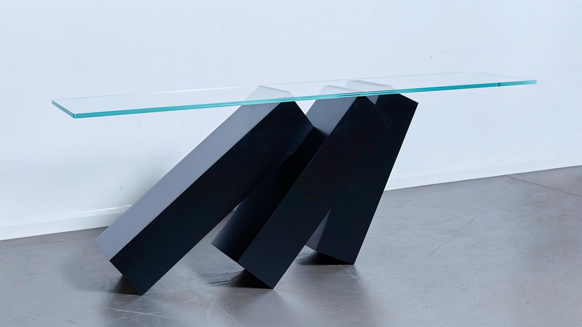 The Monolith console table is a statement piece from Duffy London, impressing with it's mind-boggling design.

A glass table balances miraculously on top of a series of toppling monoliths, appearing to defy the laws of physics and remaining in a