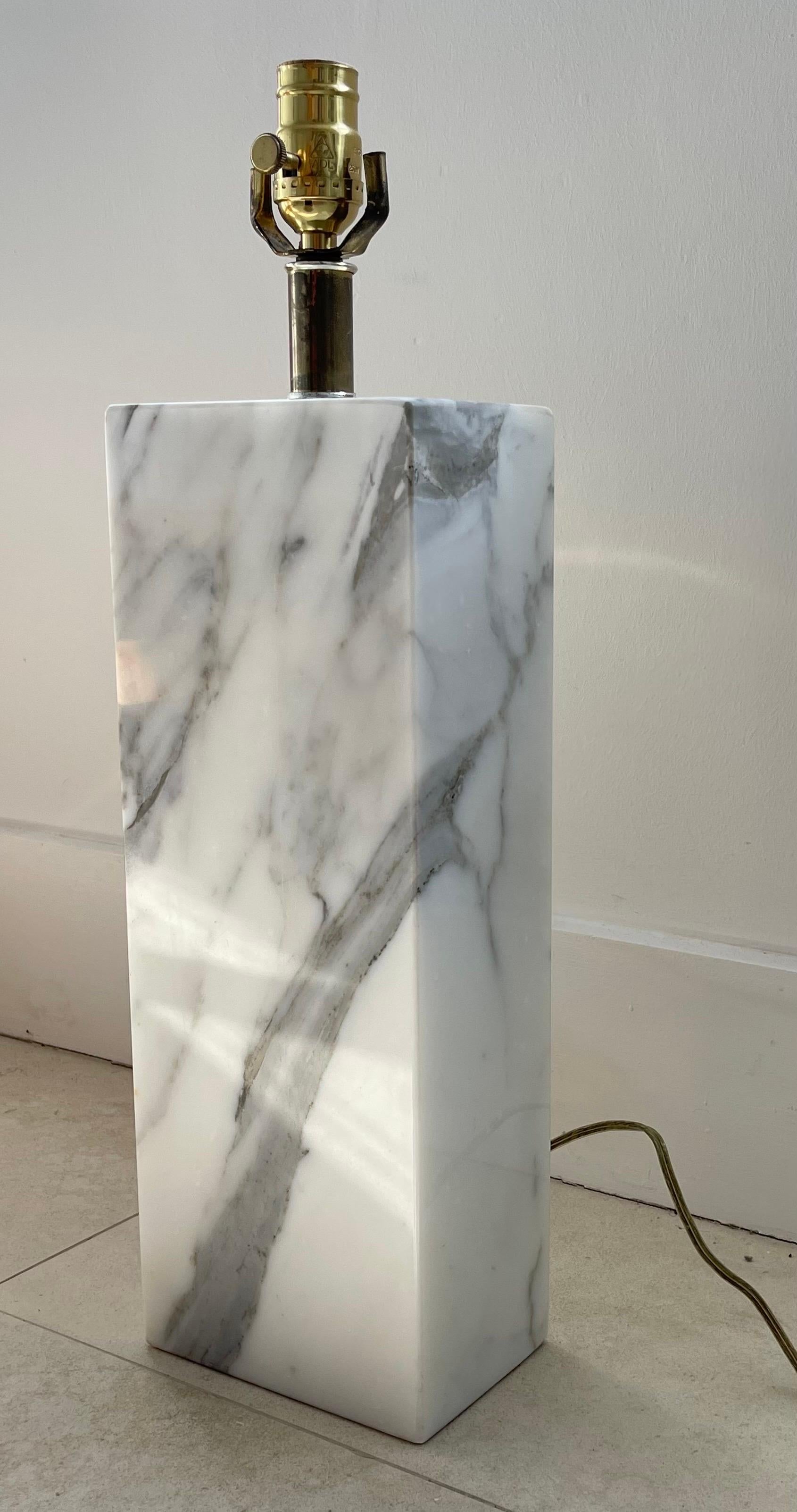 Monolithic statuary marble table lamp, rendered in a solid slab of polished statuary marble with Brass fixturing, designed by Elizabeth Kauffer for Nessen Studio Lighting, circa 1950s.

This lamp is is one of two in an unmatched asymmetrical pair.