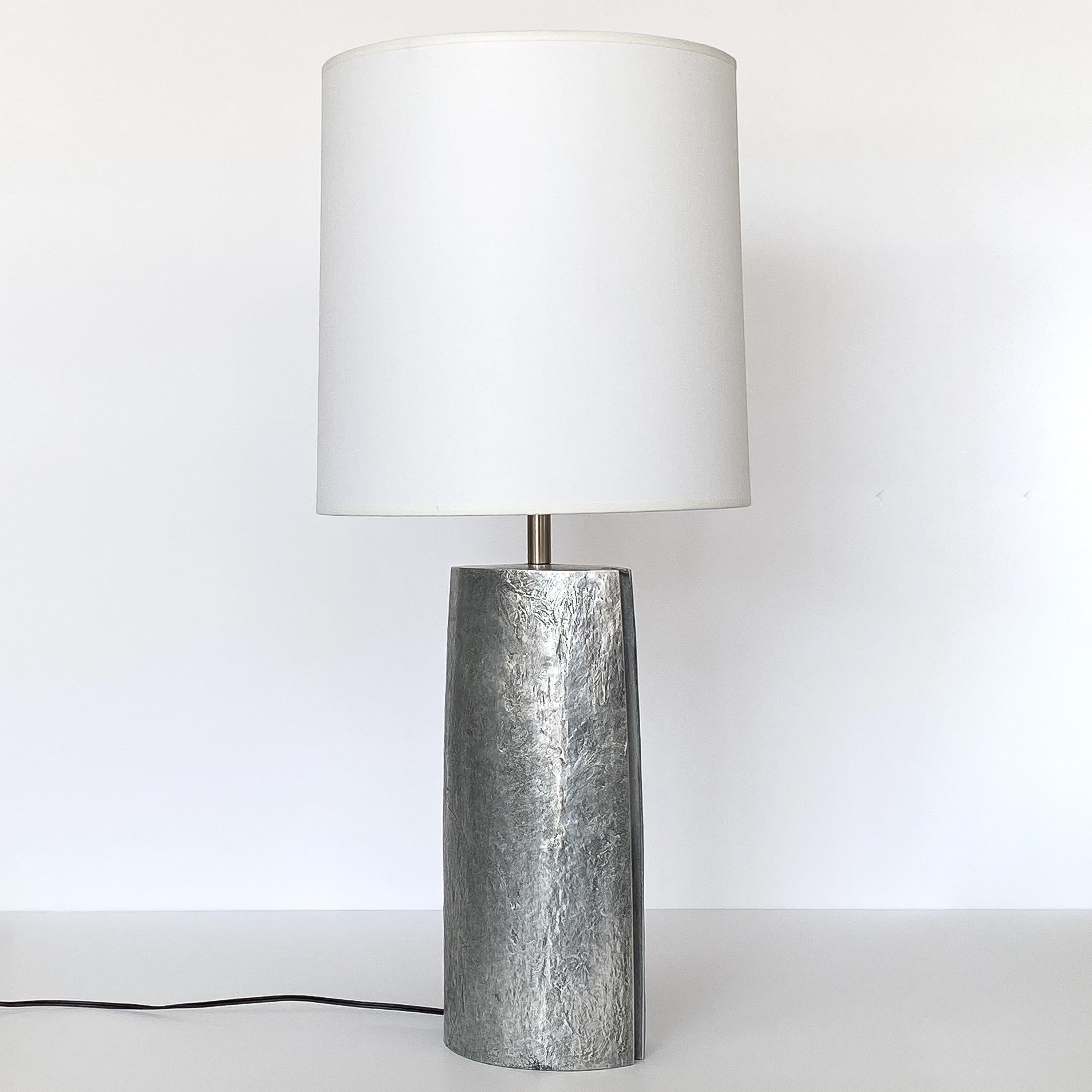 Italian Brutalist aluminum table lamp, circa 1970s. Monolithic in form, this table lamp features a solid cast aluminum body with textured finish. Marquise shape with routed details on both sides. Chrome cylinder finial and harp. Marked with the