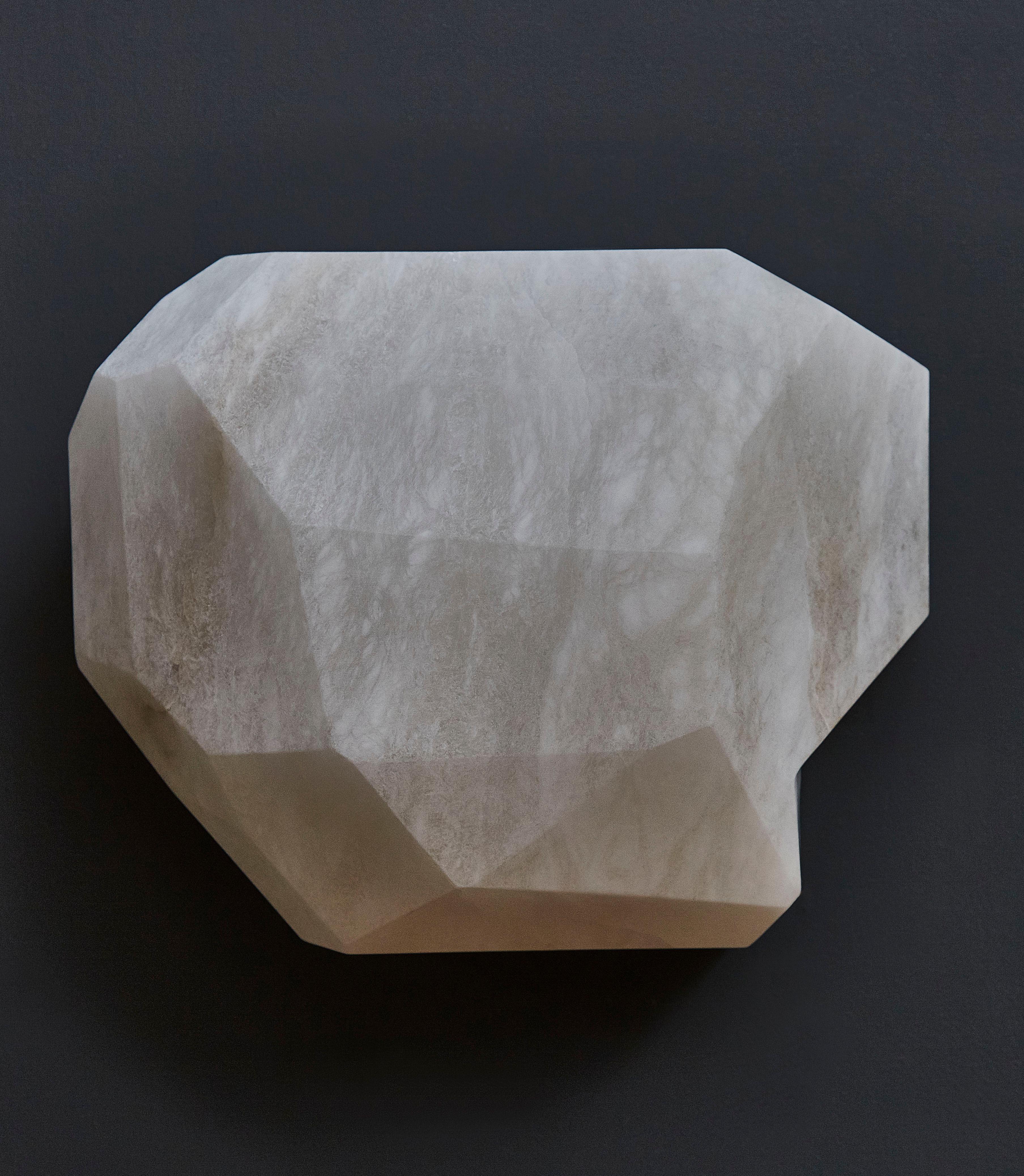 Wall sconce made of a single block of alabaster sculpted and carved to receive an inner light.