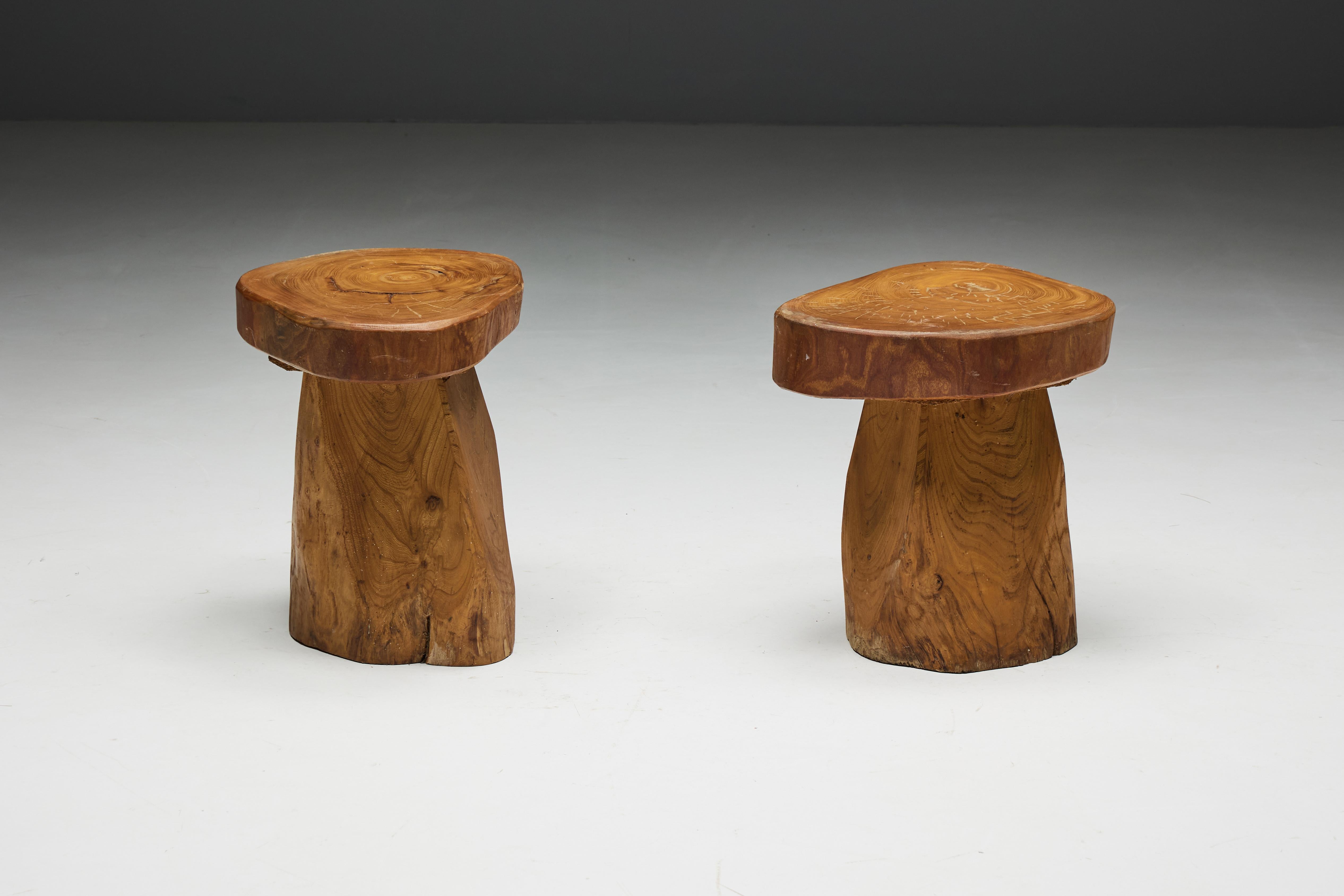 Handcarved monoxylite stools, a testament to 1970s Brazilian craftsmanship and the timeless allure of José Zanine Caldas. The natural beauty of the wood grain takes center stage, an embodiment of Caldas' mastery of form and material. With their
