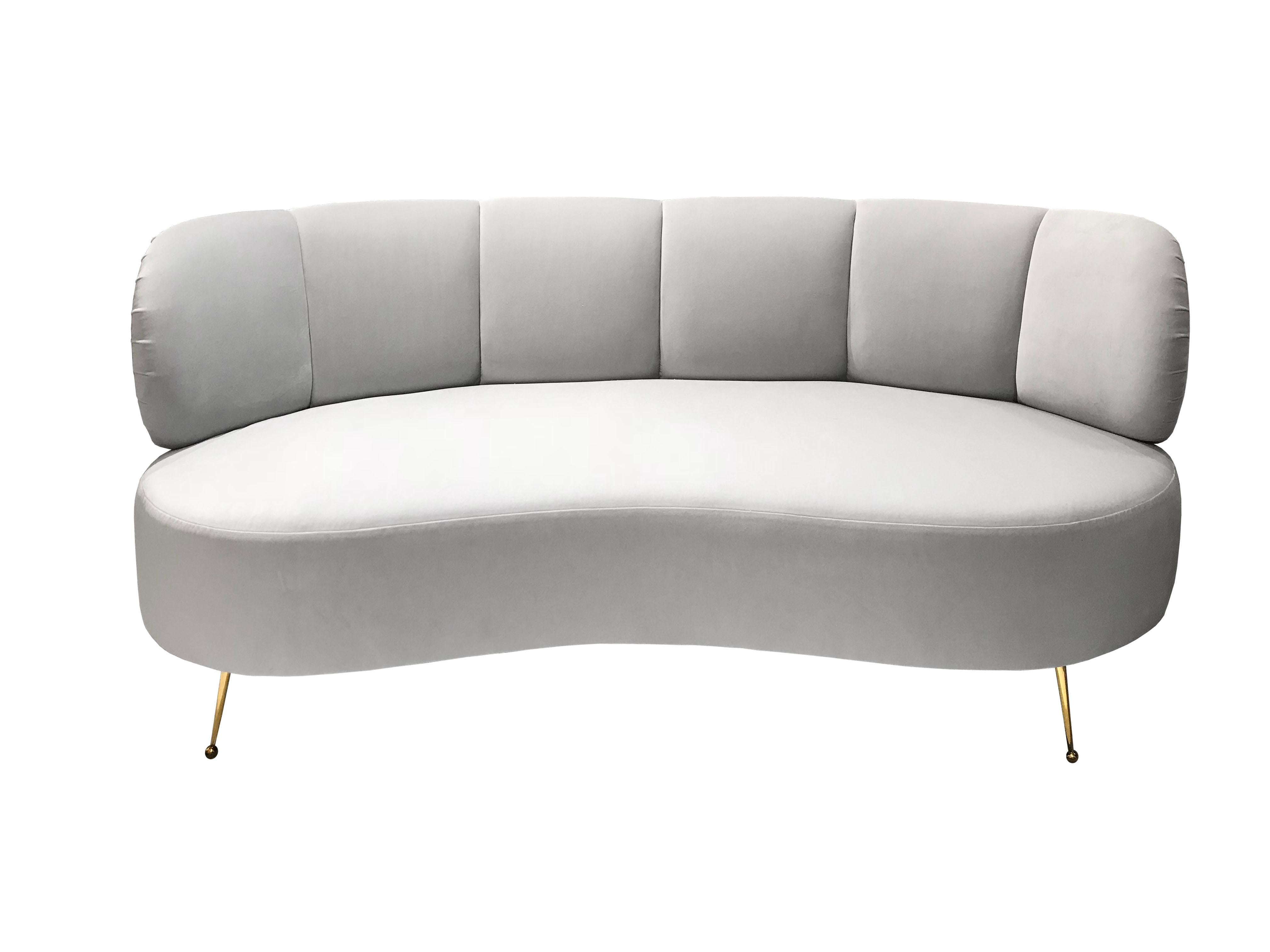 The Monroe Settee, designed by Irwin Feld Design for CF Modern, is a small plush sofa with a curved seat and back. The back is channeled and flanked by rounded arms. It stands on four angled Vivier legs. Shown here in pale grey velvet and polished