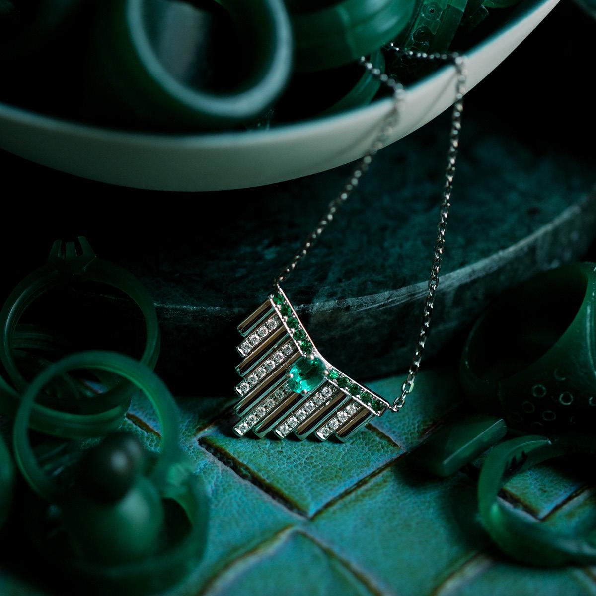 19.2K white gold pendant necklace with 26 brilliant cut diamonds with 0.21 ct., 10 tsavorites with 0.22 ct. and 1 6x4 oval emerald with 0.42 ct.

This ring is parte of Monseo 'Neo Deco' collection, This collection has several Art Deco inspired