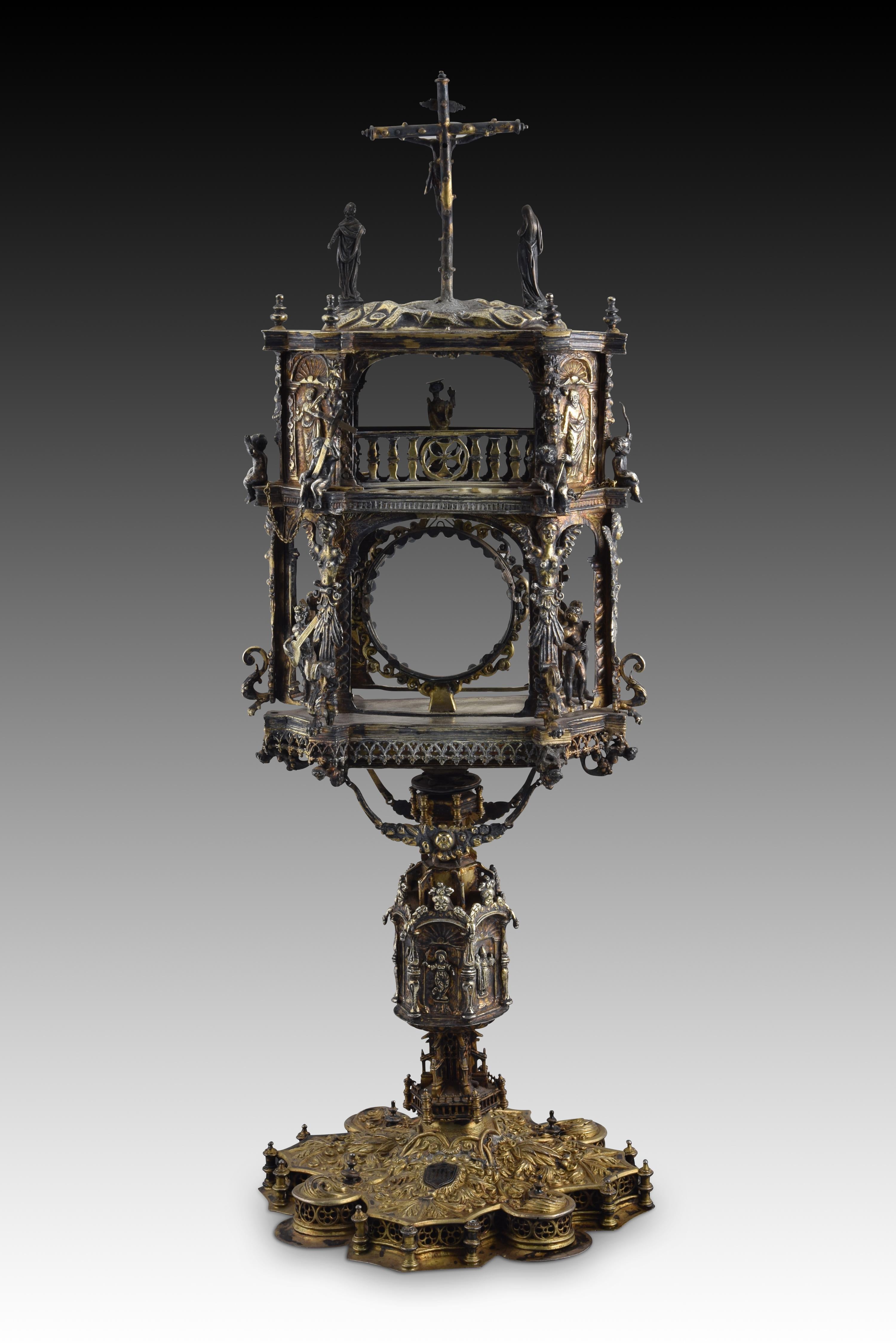 Portable temple custody. Gilded silver, glass. 16th century, possible restorations. 
Custody made of gilded silver (the finish has been lost in some points) composed of a base, an axis or stem and a two-story architectural upper structure with