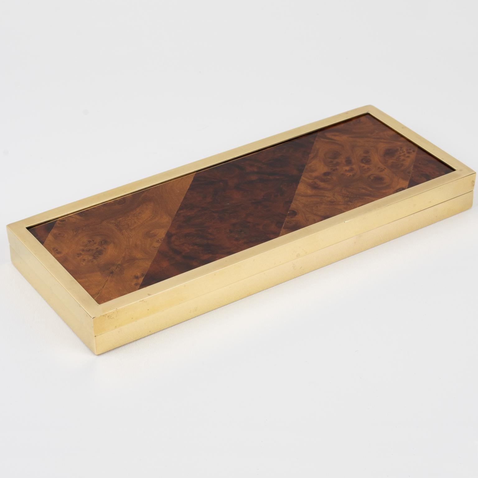 Montagnani Firenze, Italy, designed this exquisite decorative box. Its Mid-Century modernist design boasts an elongated rectangular flat shape, with burl-wood geometric marquetry veneer on the lid and polished gilded brass metal framing. The