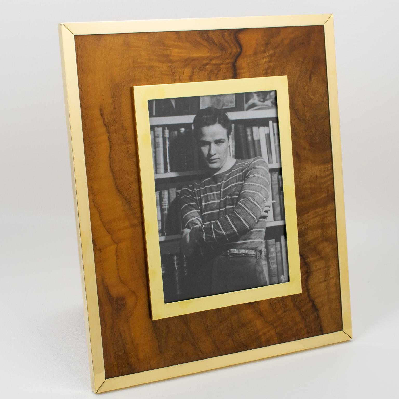 Montagnani Firenze, Italy, crafted this sophisticated picture photo frame in the 1970s. Its Mid-Century modernist design boasts a rectangular shape, with walnut wood geometric veneer complimented with polished gilded brass metal framings. The back